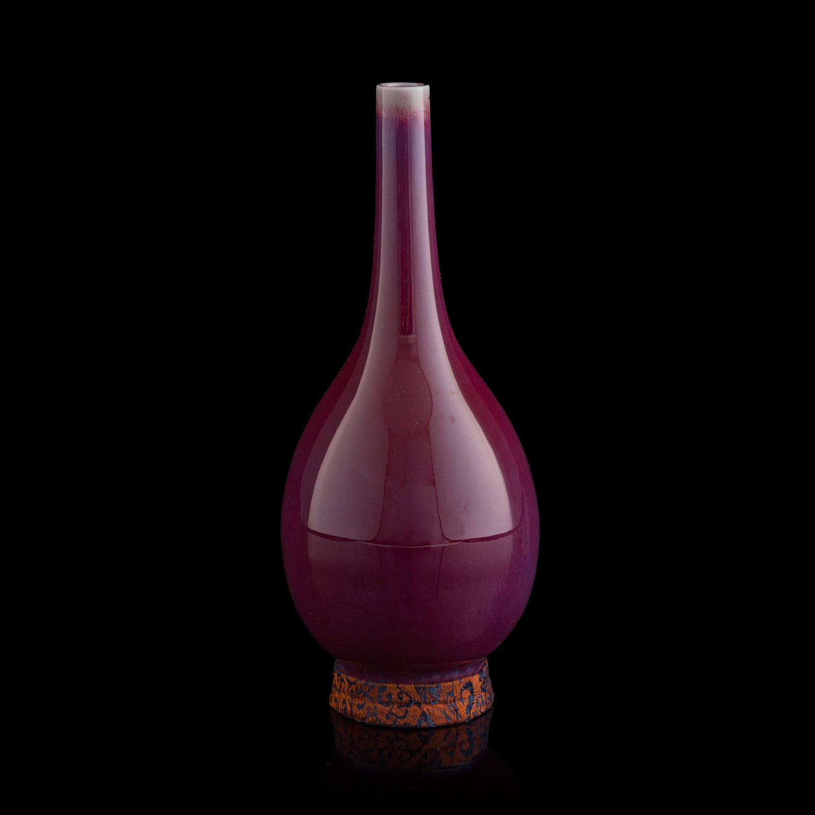 A Chinese flambe dan vase, late 19th century: A Chinese flambe dan vase late 19th century Sold with a brocade box and a brocade stand. H: 7 7/8. Dia: 3 3/8 in. (H: 20, Dia: 8.6 cm. (vase)) Private collection, Dallas, Texas.