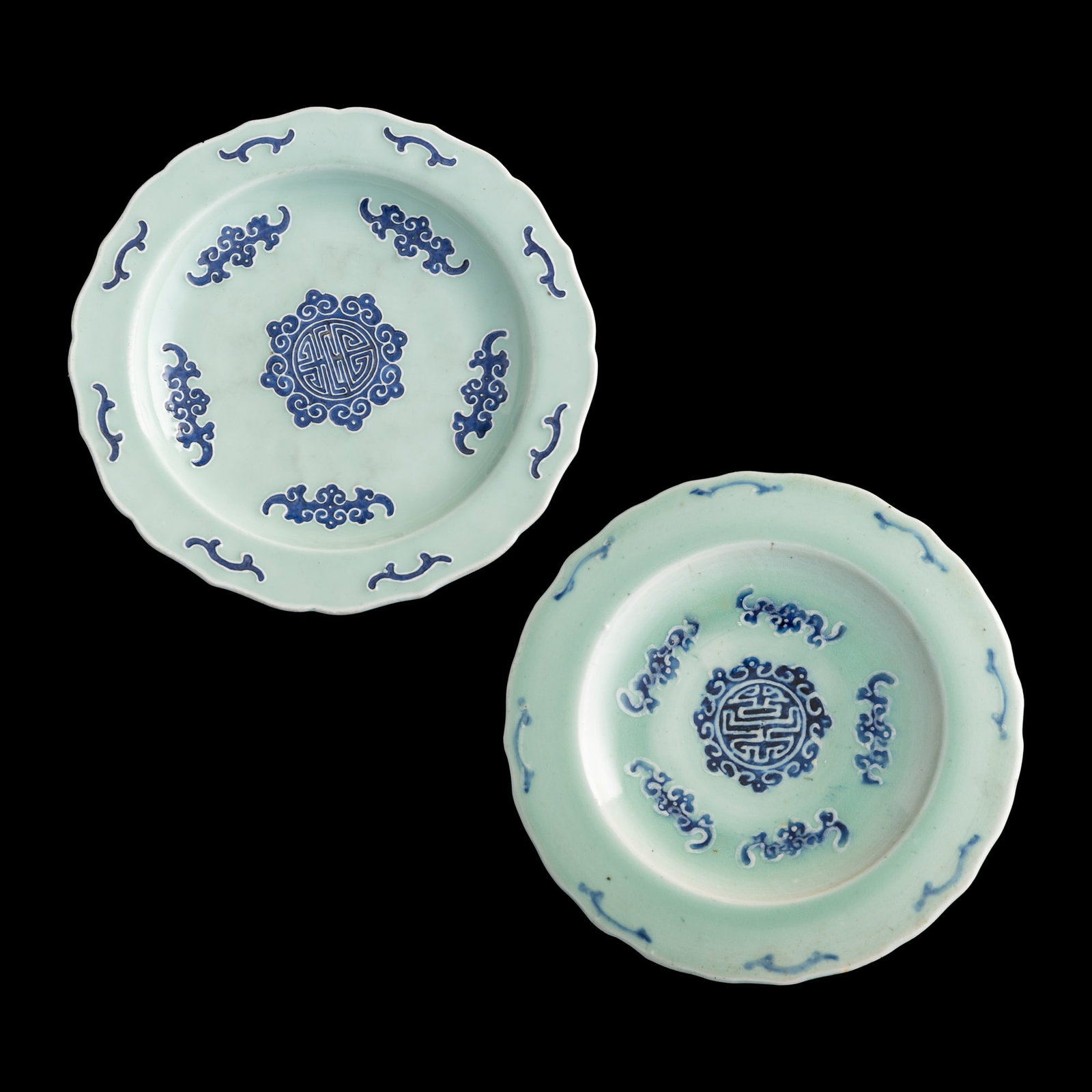 Two Chinese celadon-glazed blue-enameled plates, Qianlong period, Qing dynasty: Two Chinese celadon-glazed blue-enameled plates Qianlong period, Qing dynasty Both with central 'shou' medallion surrounded by 'bat' motif; one with four-character mark to underside, the other with si