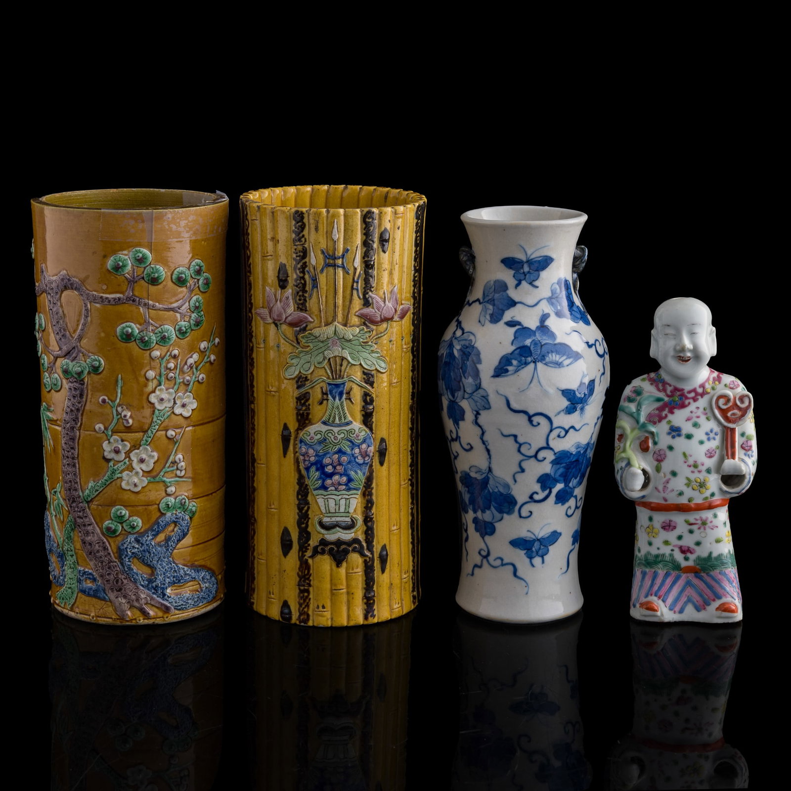 Four assorted Chinese porcelain items, Qing dynasty: Four assorted Chinese porcelain items Qing dynasty Comprising two yellow-glazed hat stands, one blue and white vase, and a famille rose figure. (4). H: 10 1/4, Dia: 4 7/8 in. (H: 26, Dia: 12.4 cm. (la