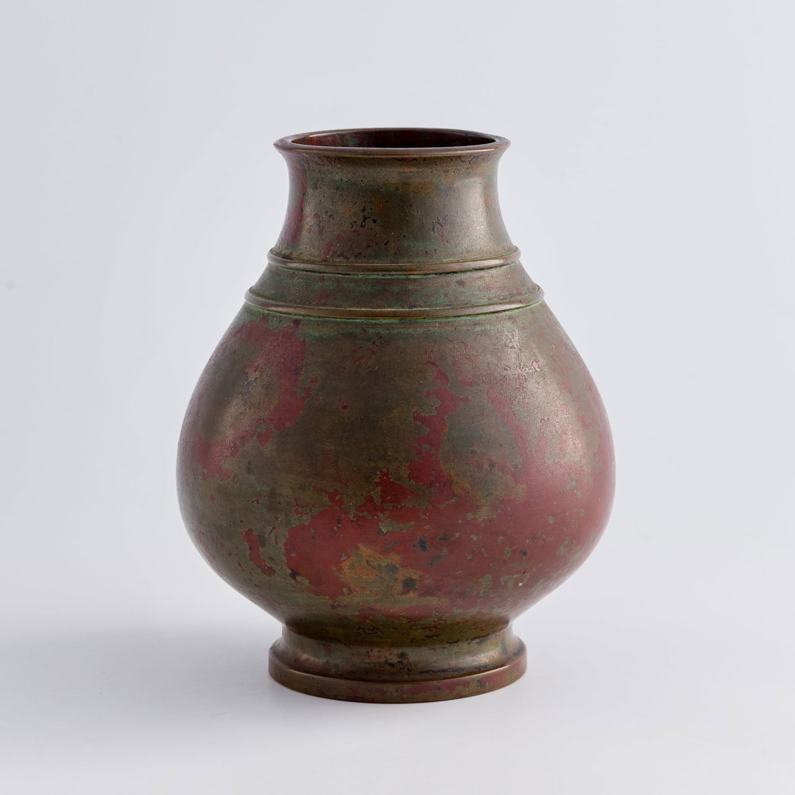 A Chinese copper-alloy 'string-band' zun-form vase, 18th century: A Chinese copper-alloy 'string-band' zun-form vase 18th century The neck features two raised bands. The whole zun has green and red patina throughout. H: 7, Dia: 5 5/8 in. (H: 17.8, Dia: 14.3 cm.) Wei