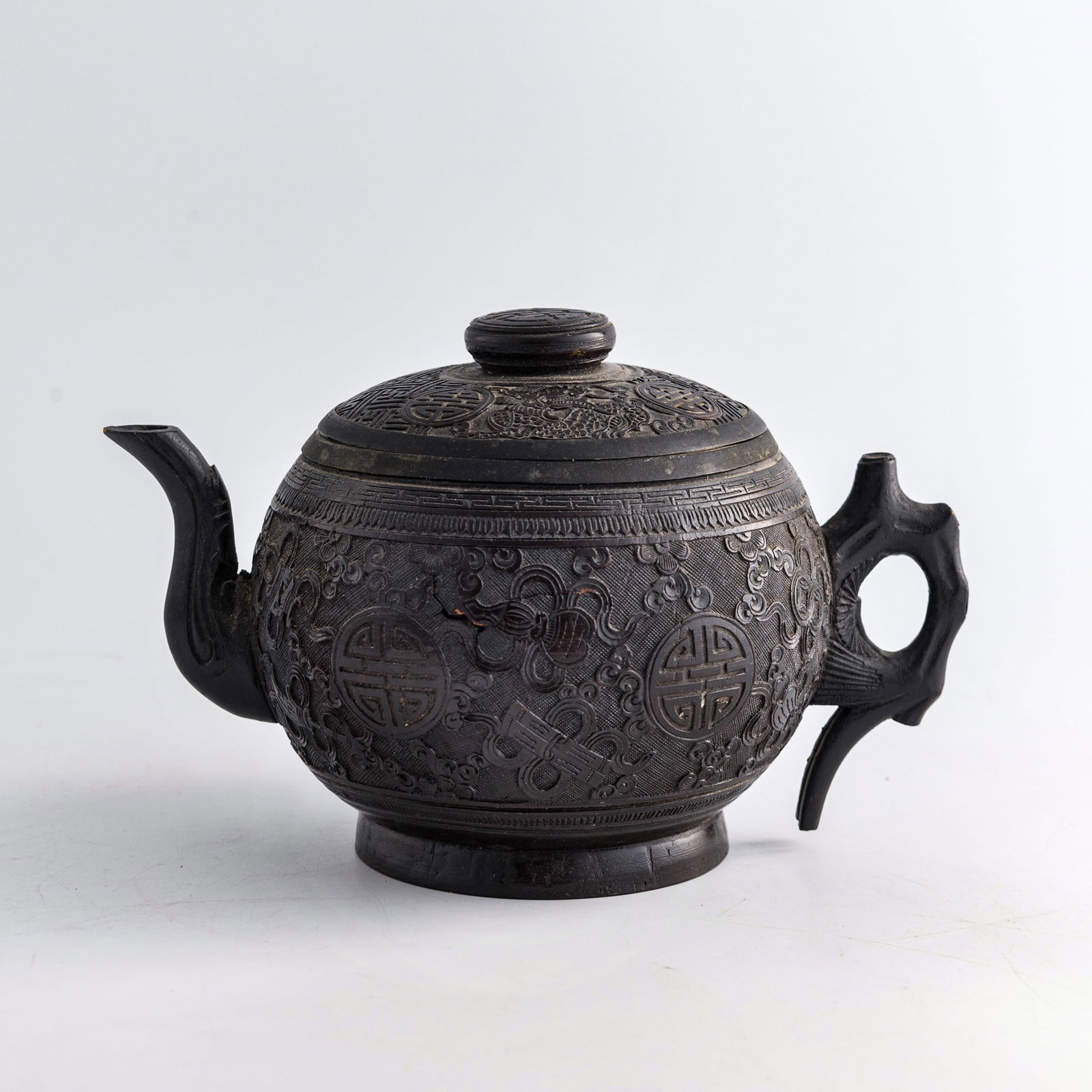 A Chinese carved coconut shell 'shou' teapot, late 19th century: A Chinese carved coconut shell 'shou' teapot late 19th century H: 4 7/8, W: 7 5/8, D: 5 in. (H: 12.4, W: 19.4, D: 12.7 cm.) Private collection, Purcellville, Virginia.
