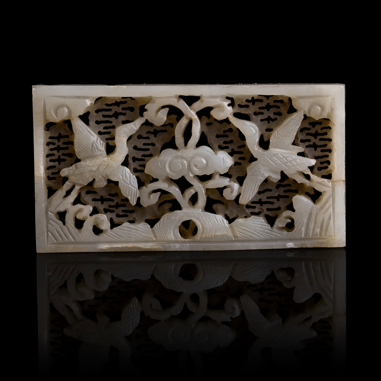 A Chinese white jade openwork 'clouds and cranes' belt plaque, Ming dynasty: A Chinese white jade openwork 'clouds and cranes' belt plaque Ming dynasty H: 1 3/8, W: 2 5/8, D: 1/4 in. (H: 3.5, W: 6.7, D: 0.6 cm.) From Mr. Kwok of Vancouver, Canada. Inherited from his late