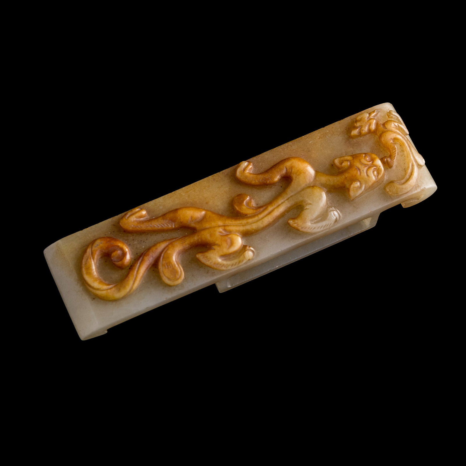 A Chinese carved jade 'chilong' sword fitting, Ming dynasty: A Chinese carved jade 'chilong' sword fitting Ming dynasty H: 5/8, W: 3 3/4, D: 1 in. (H: 1.6, W: 9.5, D: 2.5 cm.) From Mr. Kwok of Vancouver, Canada. Inherited from his late father, who acquired the
