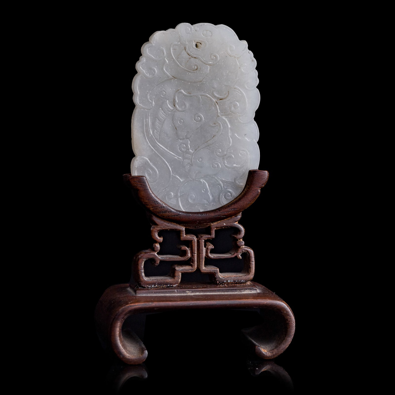 A Chinese white jade 'kui dragon' plaque, 18th century: A Chinese white jade 'kui dragon' plaque 18th century Sold with hardwood stand. Plaque: H: 2 1/4, W: 1 1/2, D: 3/16 in. (H: 5.7, W: 3.8, D: 0.5 cm.) From Mrs. Kiang of Solana Beach, California.