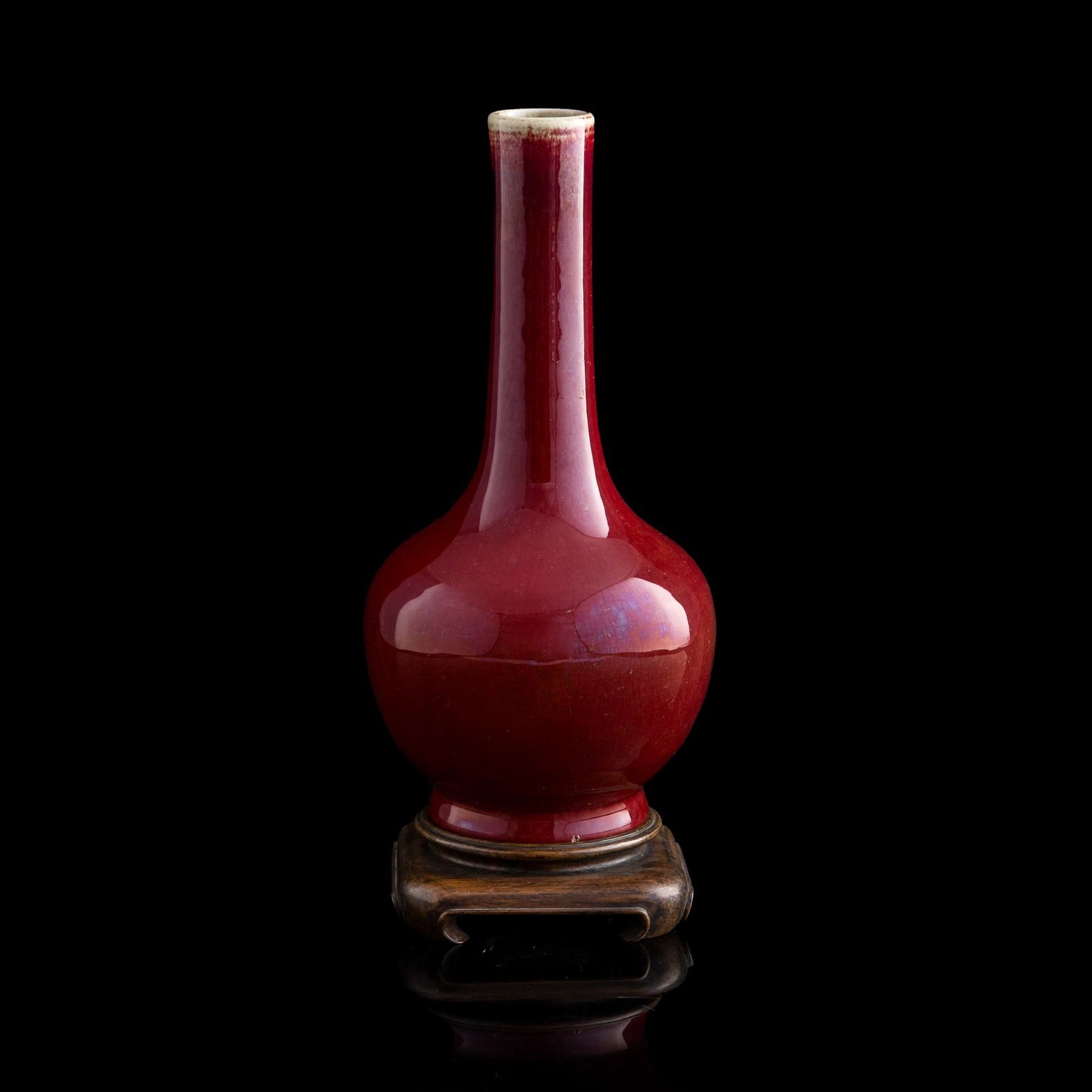 A Chinese flambe-glazed bottle vase, early 19th century: A Chinese flambe-glazed bottle vase early 19th century Sold with associated wooden stand. H: 9 1/2, Dia: 4 1/2 in. (H: 24.1, Dia: 11.4 cm.) From Mr. Kwok of Vancouver, Canada. Inherited from his late 