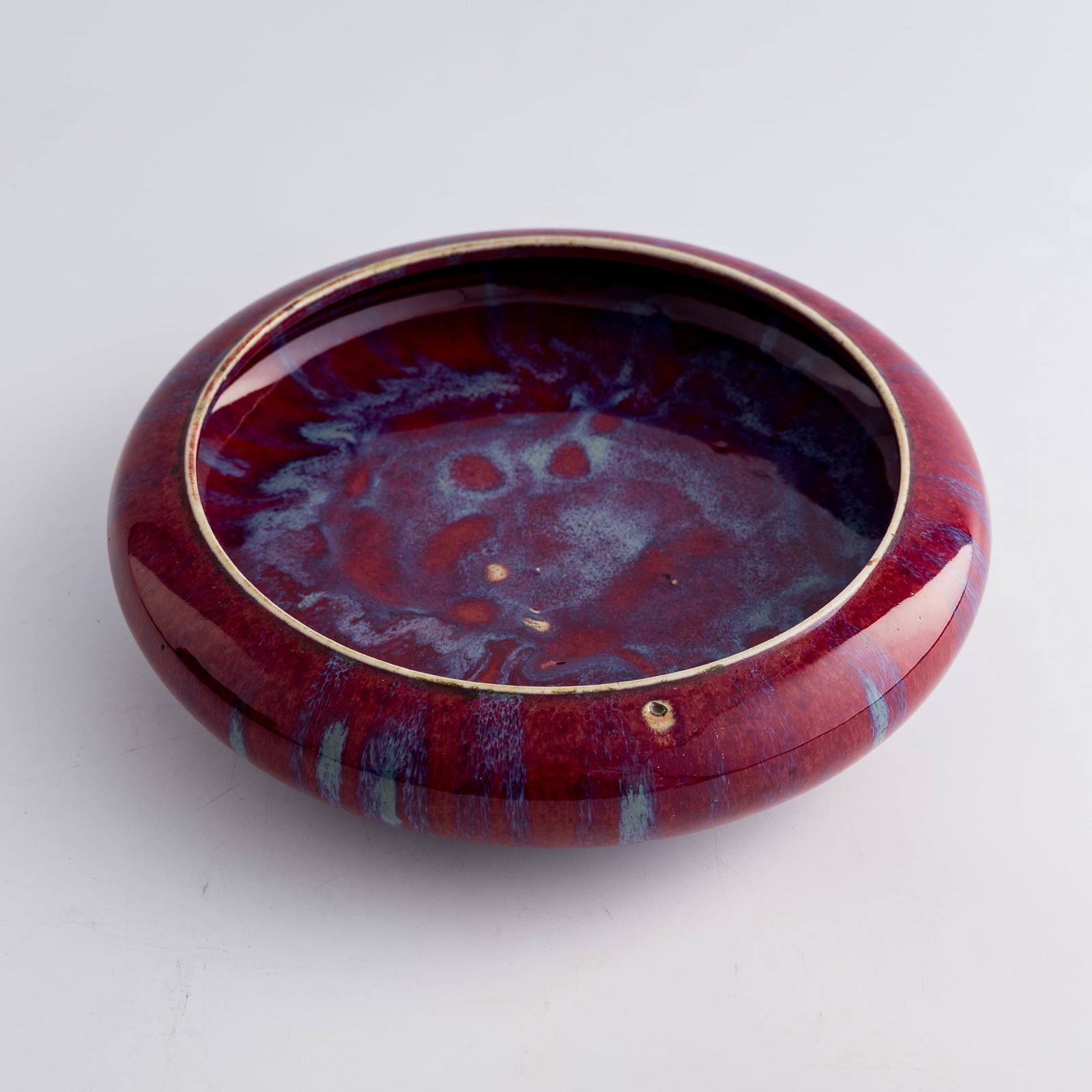 A Chinese flambe-glazed brush washer, Qing dynasty: A Chinese flambe-glazed brush washer Qing dynasty H: 2 1/2, Dia: 9 7/8 in. (H: 6.4, Dia: 25.1 cm.) From Mrs. Foo of Vancouver, Canada. Inherited from her parents-in-law; the item was acquired in Hong 
