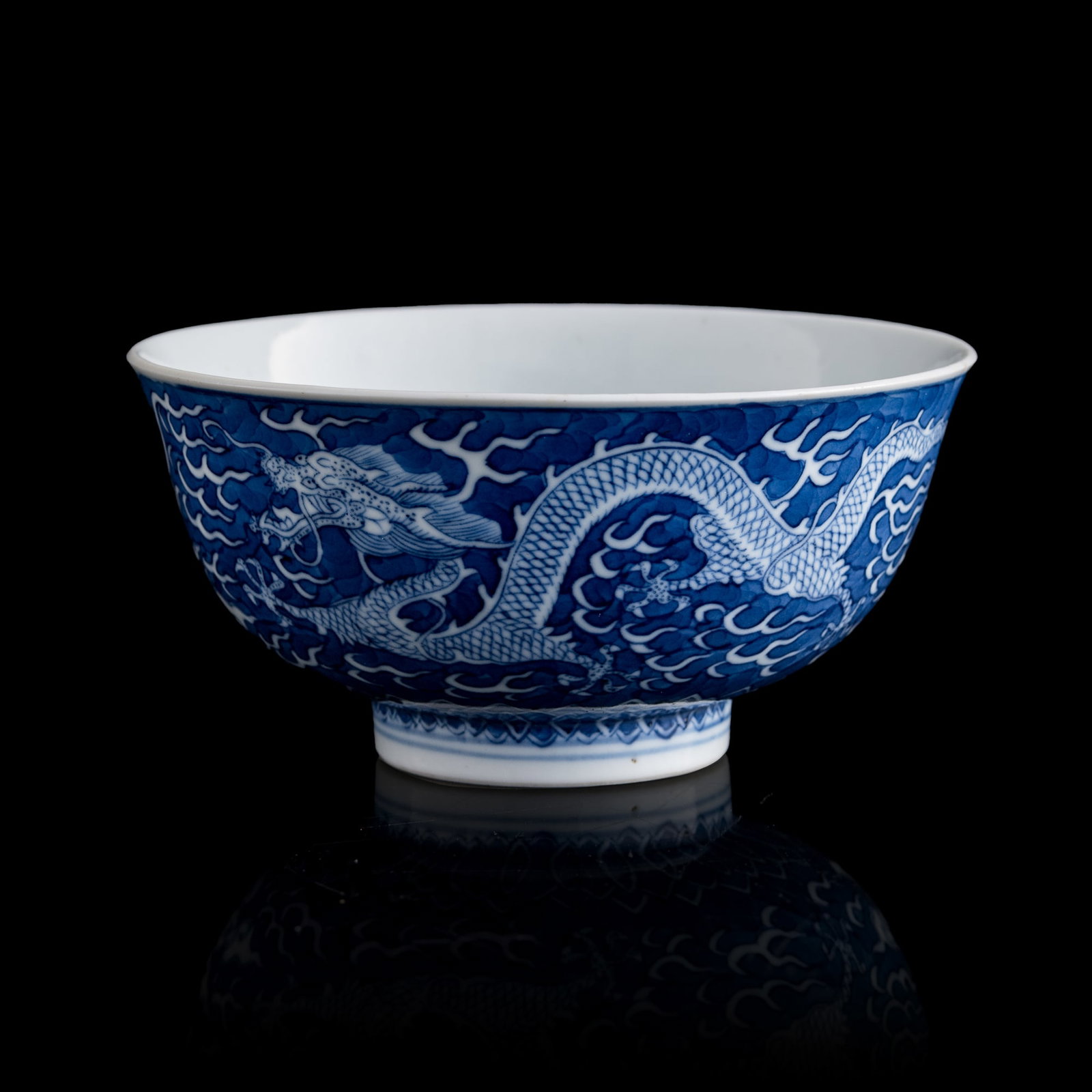 A Chinese blue-ground and white-reserved 'dragon' bowl, Guangxu period, Qing dynasty: A Chinese blue-ground and white-reserved 'dragon' bowl Guangxu period, Qing dynasty The interior is decorated with a dragon within a double-line medallion. The exterior is painted with two dragons cha