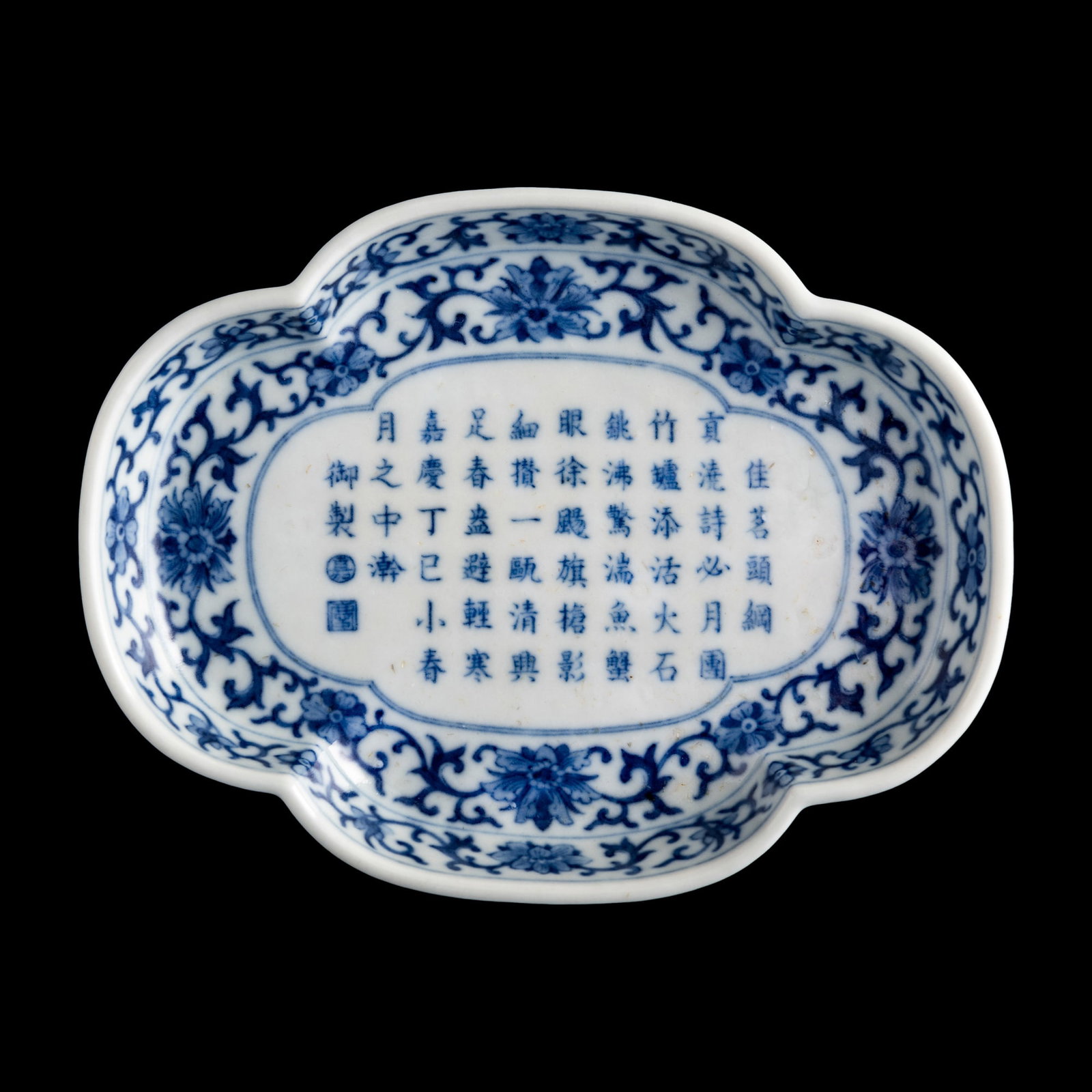 A Chinese blue and white quatrefoil-rim saucer with imperial poem, Jiaqing period, Qing dynasty: A Chinese blue and white quatrefoil-rim saucer with imperial poem Jiaqing period, Qing dynasty Inscribed with poem to front about the joys of imperial tea composed by the Jiaqing Emperor and six-chara