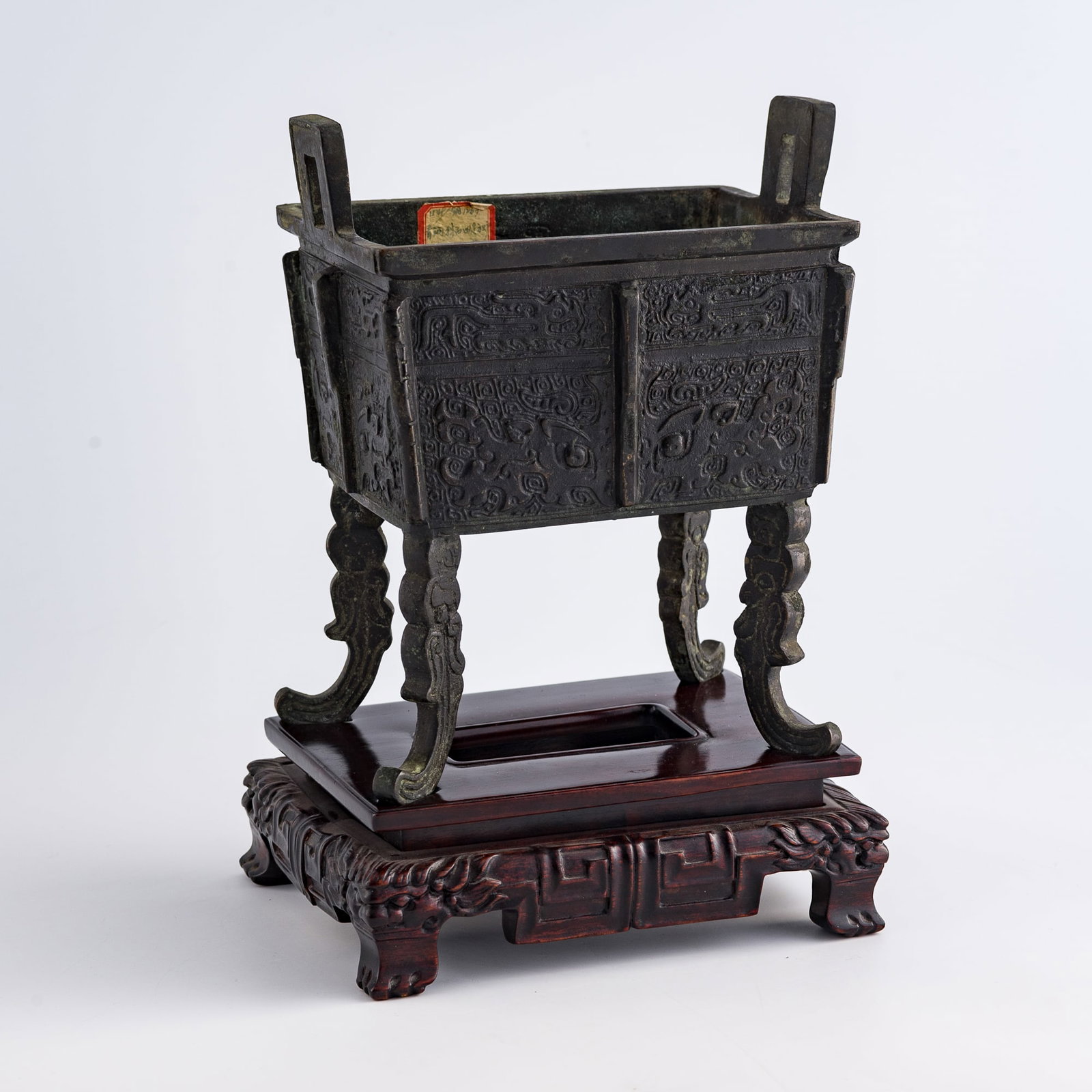 A Chinese bronze square ding, Ming dynasty: A Chinese bronze square ding Ming dynasty with hardwood stand H: 8, W: 6 1/4, D: 4 1/2 in. (H: 20.3, W: 15.9, D: 11.4 cm.) Weight: 16380 g From an estate in Orange County, California.