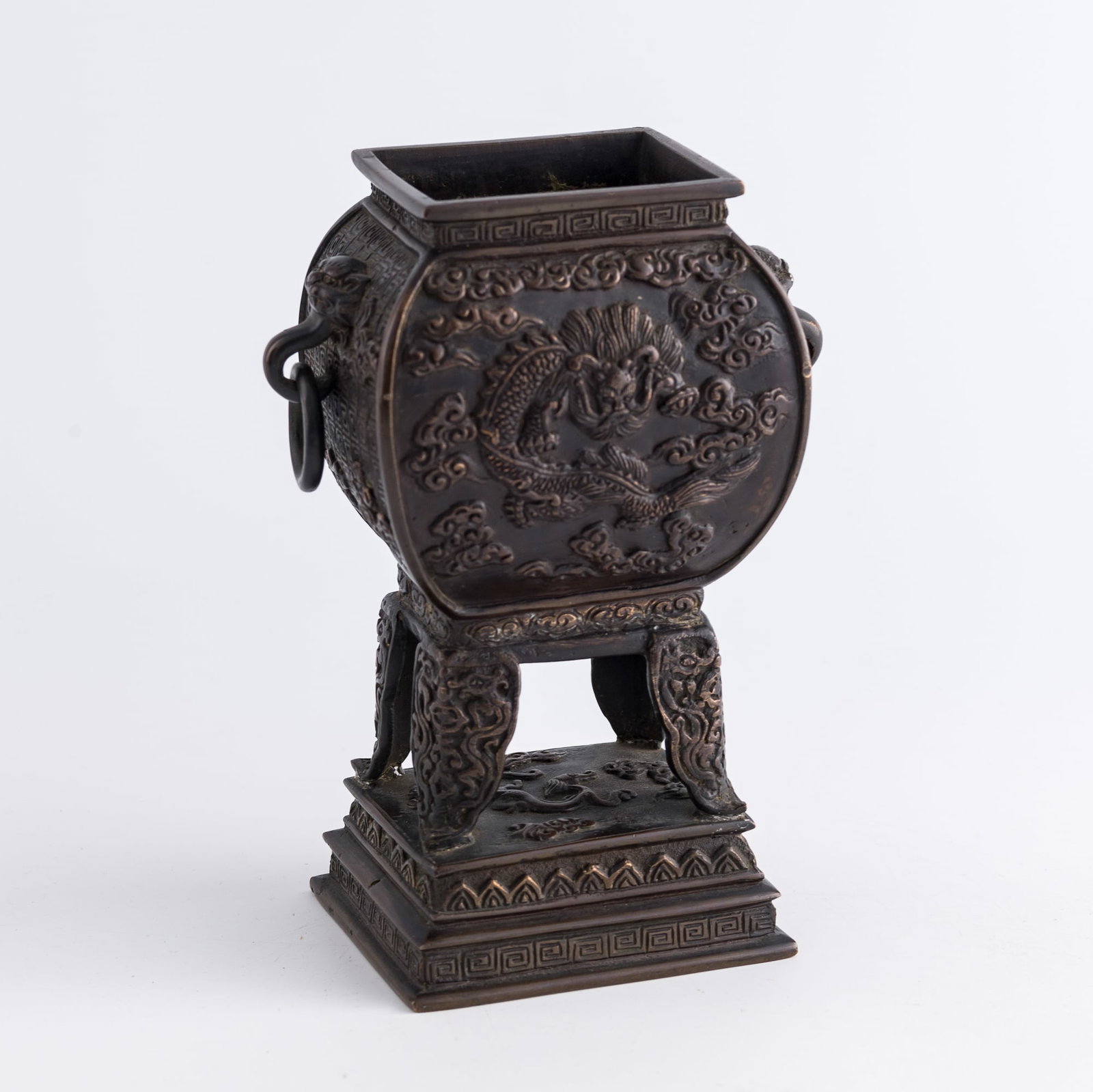 A Chinese bronze four-legged figural censer, 18th century: A Chinese bronze four-legged figural censer 18th century one side with illustration of Taoist immortals; other side with illustration of coiling dragon H: 6 3/4, W: 5, D: 3 in. (H: 17.1, W: 12.7, D: 7