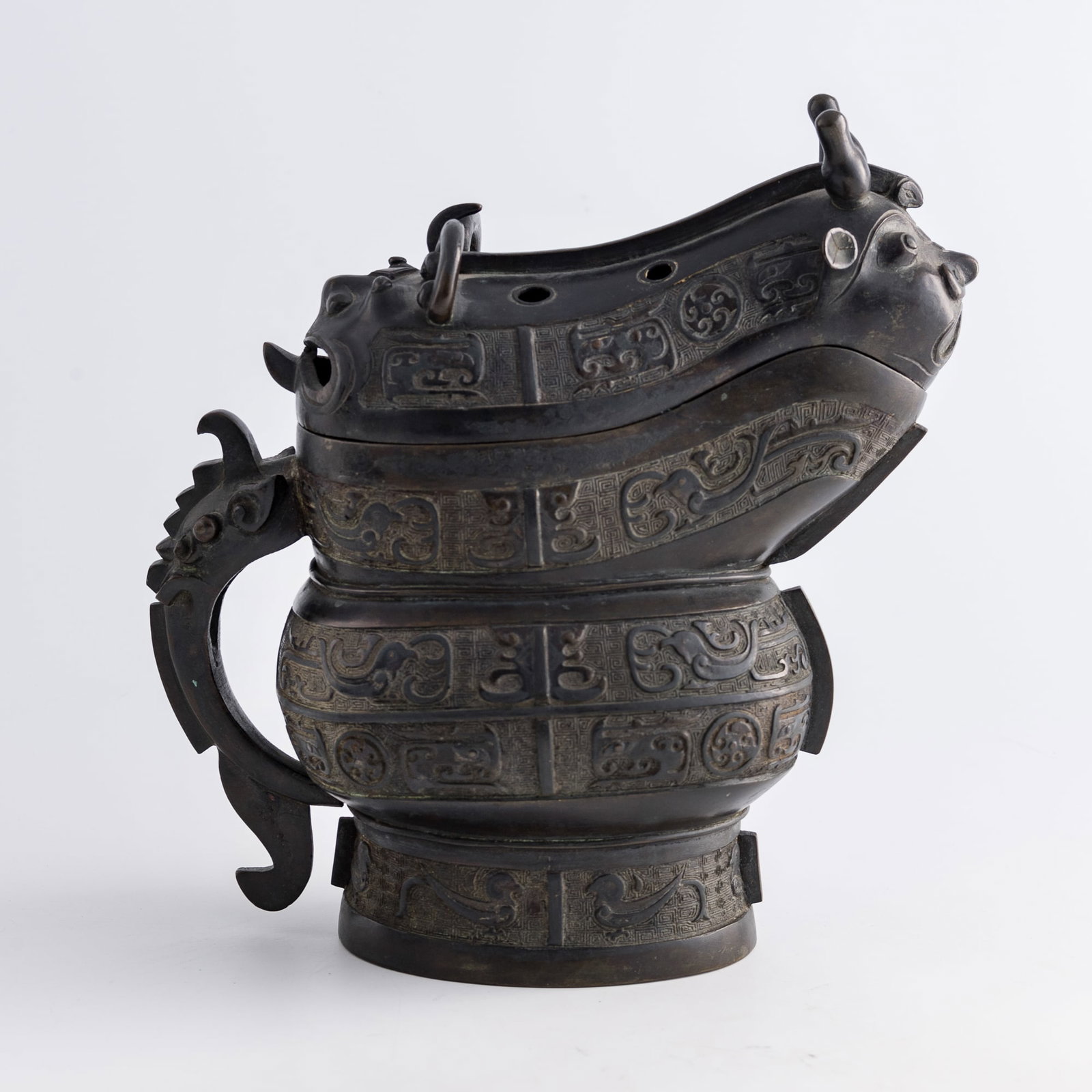 A Chinese bronze taotie-decorated gong vessel, Ming dynasty: A Chinese bronze taotie-decorated gong vessel Ming dynasty H: 10 3/8, W: 9 1/2, D: 5 1/4 in. (H: 26.4, W: 24.1, D: 13.3 cm.) Weight: 2534 g From an estate in San Diego, California.