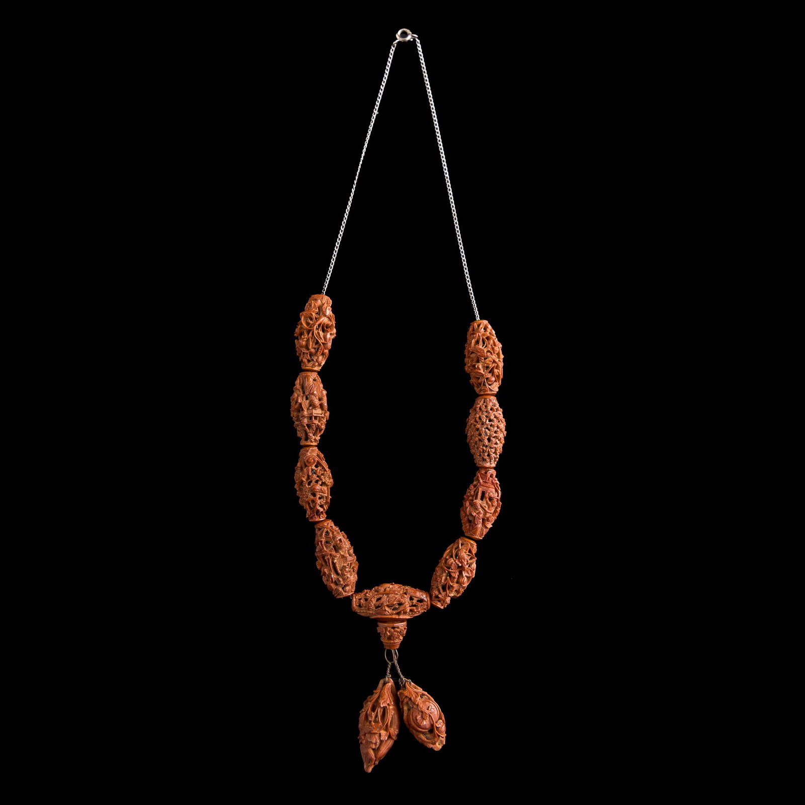 A Chinese carved pit necklace, 19th century: A Chinese carved pit necklace 19th century Metal chain with "STERLING" mark to clasp. L: 9 in. (22.9 cm.) Bead: H: 28.7, Dia: 13.1 mm Private collection, Laurel, Maryland.