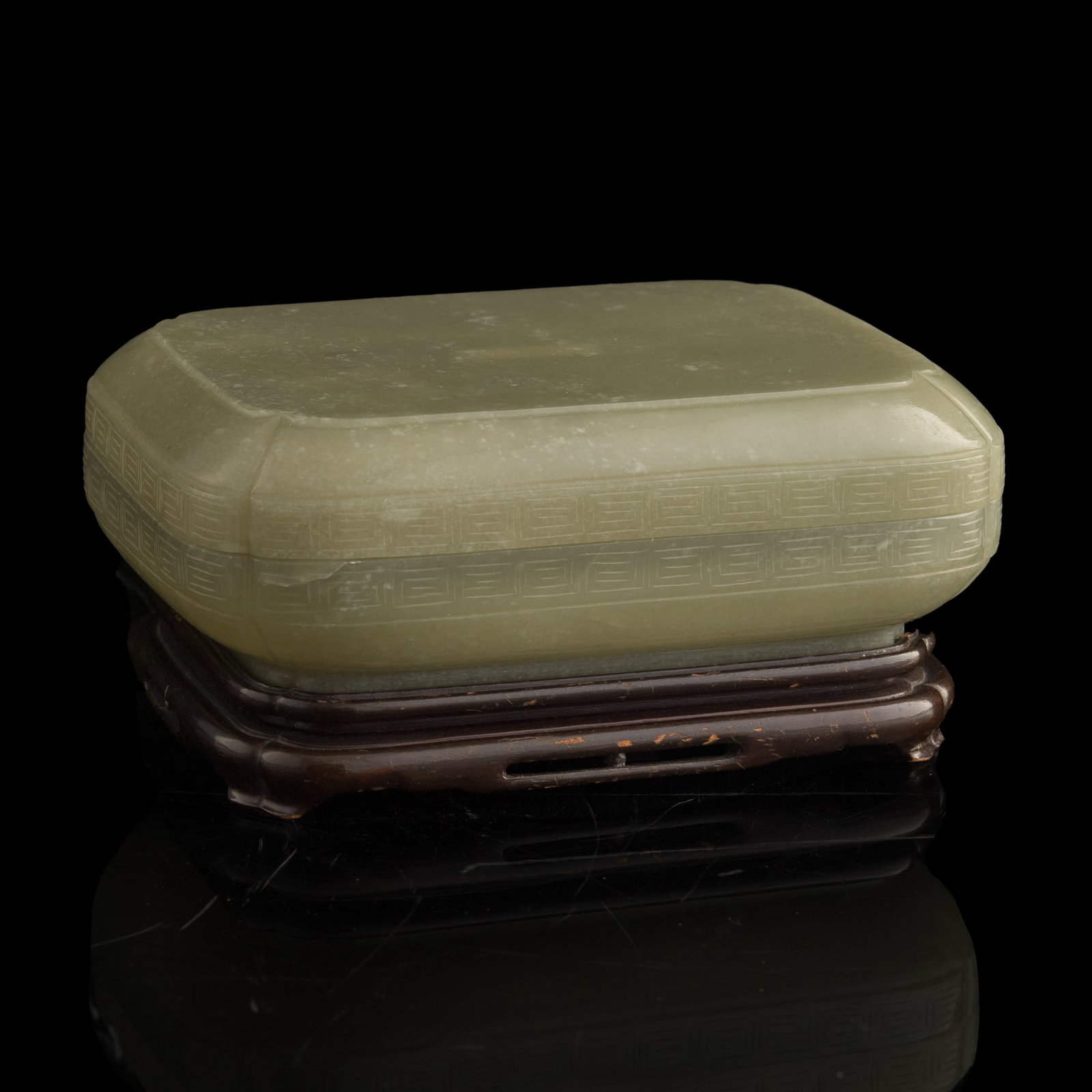 A Chinese celadon jade box, Qing dynasty: A Chinese celadon jade box Qing dynasty Sold with a hardwood stand and a fitted box; includes multiple stickers and tags from previous Christie's auction. H: 2 1/2, W: 7 1/4, D: 5 1/4 in. (H: 6.4, W: 