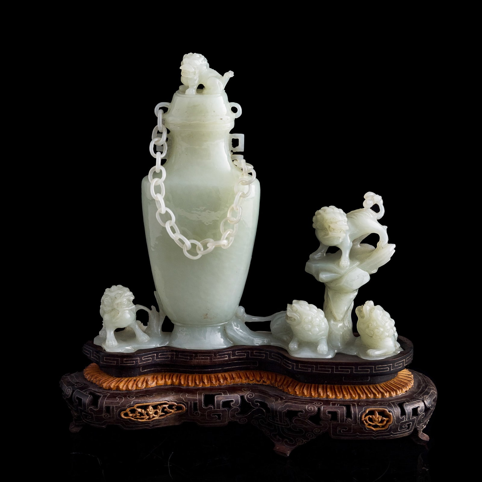 A Chinese white jade 'five lions' lidded vase with loose chain, 19th century: A Chinese white jade 'five lions' lidded vase with loose chain 19th century Exquisitely carved with five lions arranged throughout: one forming the lid finial, another standing atop a rock and looking