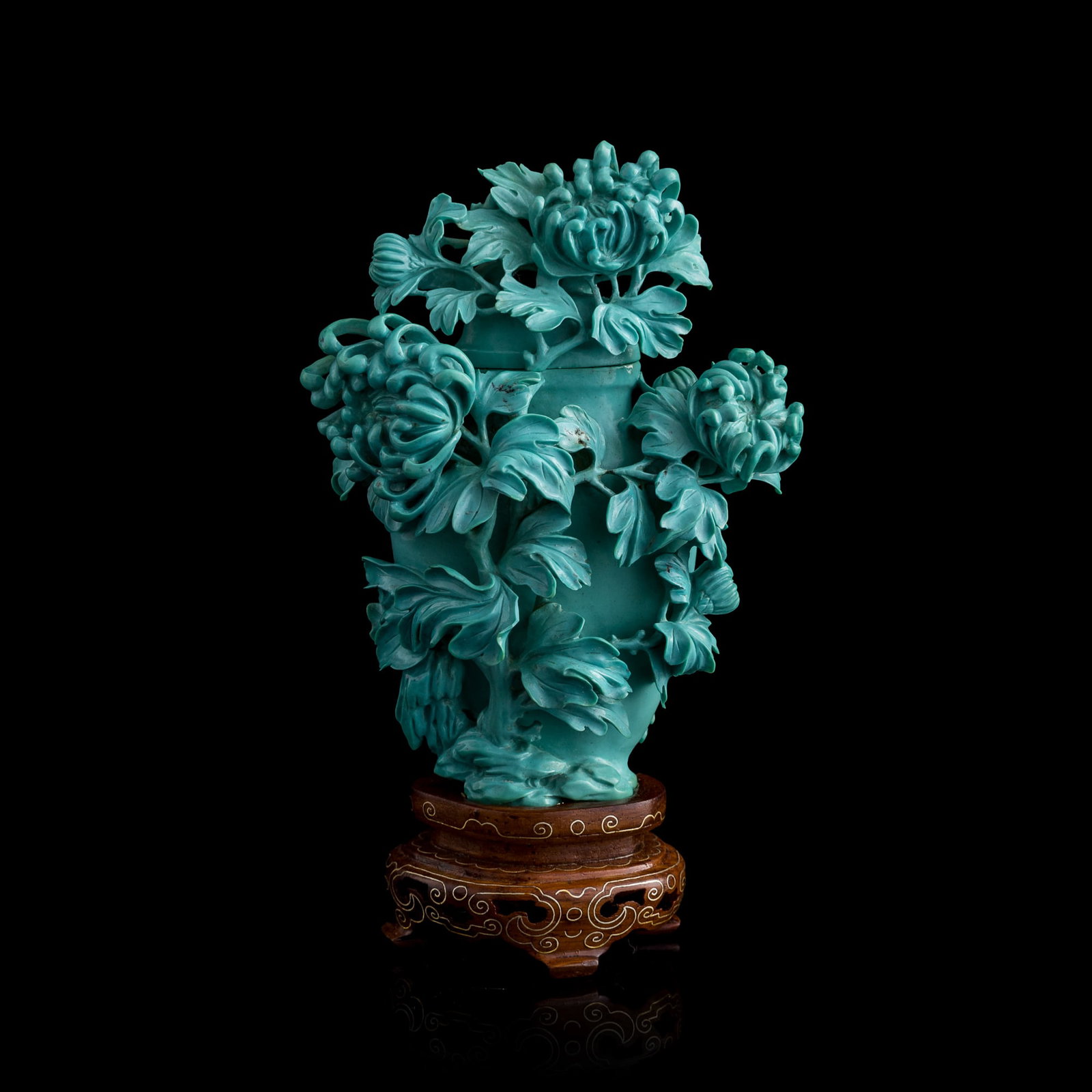 A Chinese carved turquoise 'floral' covered vase, 1960s-1970s: A Chinese carved turquoise 'floral' covered vase 1960s-1970s Sold with associated wooden stand. H: 4 1/4, W: 3 1/8, D: 2 in. (H: 10.8, W: 7.9, D: 5.1 cm. (turquoise)) Weight: 181.9 g From Mr. Wong of 
