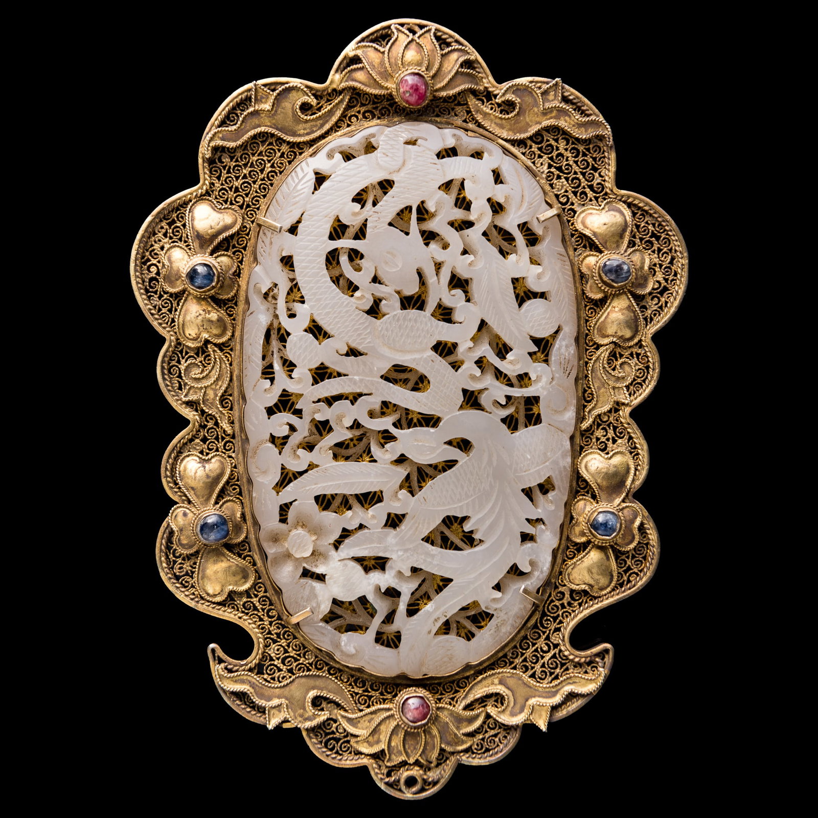A Chinese gilt-silver filigree-mounted white jade plaque, Ming dynasty (jade): A Chinese gilt-silver filigree-mounted white jade plaque Ming dynasty (jade) Overall: H: 4, W: 5 1/2, D: 3/8 in. (H: 10.2, W: 14, D: 1 cm.) Jade: H: 2 3/8, W: 3 7/8 in. (H: 6, W: 9.8 cm.) Private coll