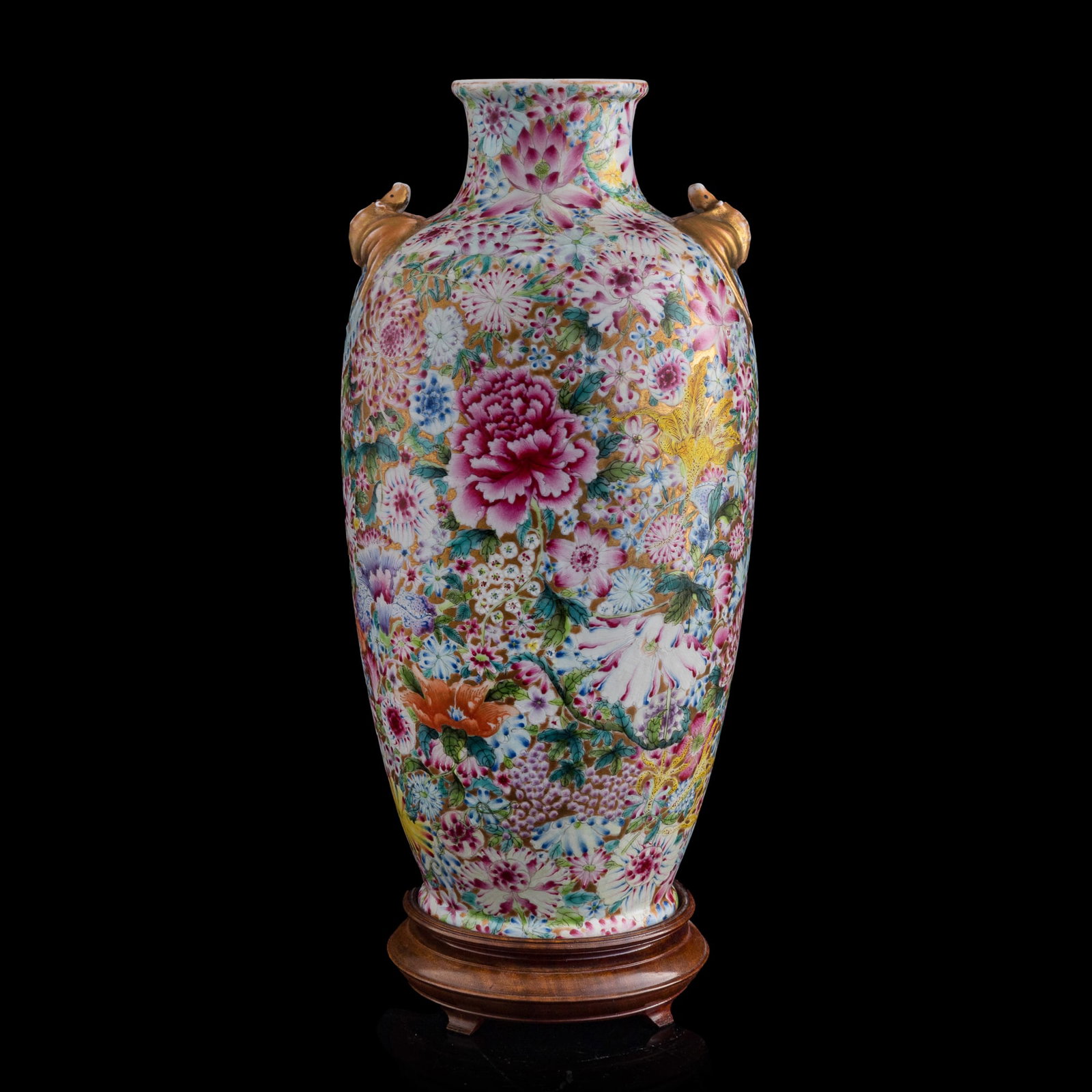 A Chinese famille rose 'millefleurs' vase with bat-form handles, Republic period: A Chinese famille rose 'millefleurs' vase with bat-form handles Republic period With six-character mark to underside. Sold with associated wooden stand. H: 13 3/4, Dia: 7 in. (H: 34.9, Dia: 17.8 cm. (