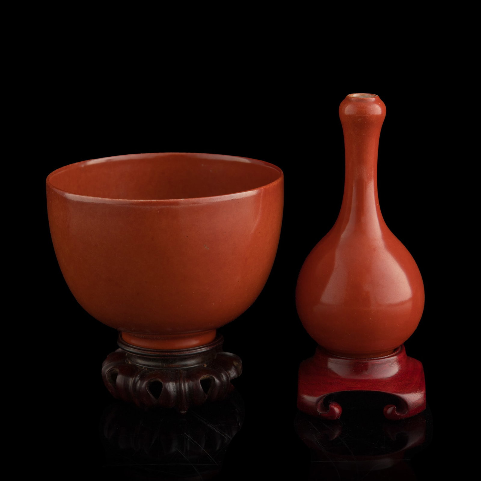 A Chinese coral-red-glazed bowl and garlic-head vase, 18th/19th century: A Chinese coral-red-glazed bowl and garlic-head vase 18th/19th century Bowl with six-character mark to underside. Sold with a fitted brocade box that holds both pieces, each includes accompanying wood