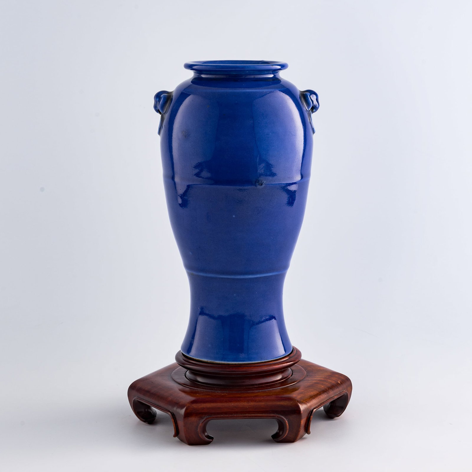 A Chinese sacrificial-blue-glazed vase with beast-mask handles, 19th century: A Chinese sacrificial-blue-glazed vase with beast-mask handles 19th century with six-character mark to underside; sold with wooden stand H: 10 1/4, W: 5 3/4, D: 4 3/4 in. (H: 26, W: 14.6, D: 12.1 cm.)