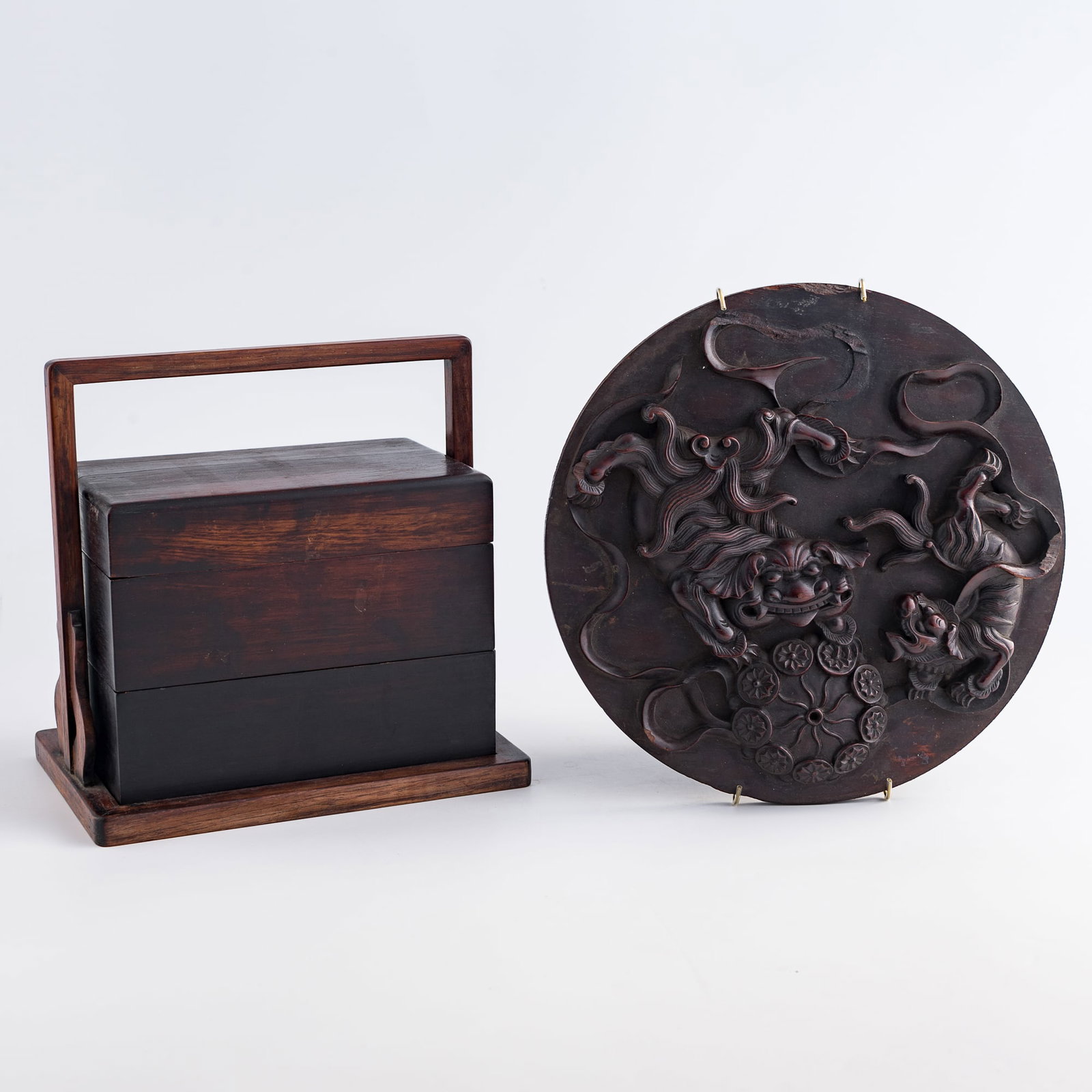 A Chinese Zitan tiered carrying box and a hardwood 'lion' plaque, Qing dynasty or later (1 of 9)
