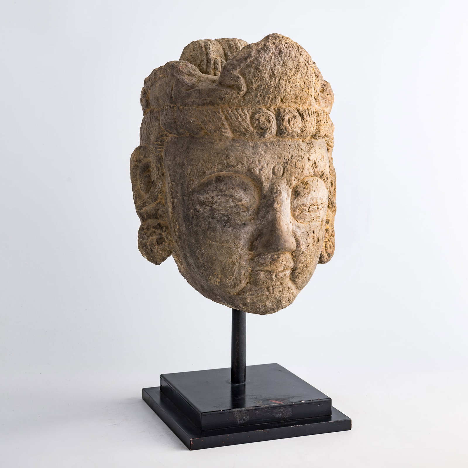 A Chinese stone Bodhisattva head, Tang dynasty: A Chinese stone Bodhisattva head Tang dynasty Based on the headdress, the circular mark on the forehead, the bun-like protrusion on the top of the head, and the elongated earlobes, this stone head is 