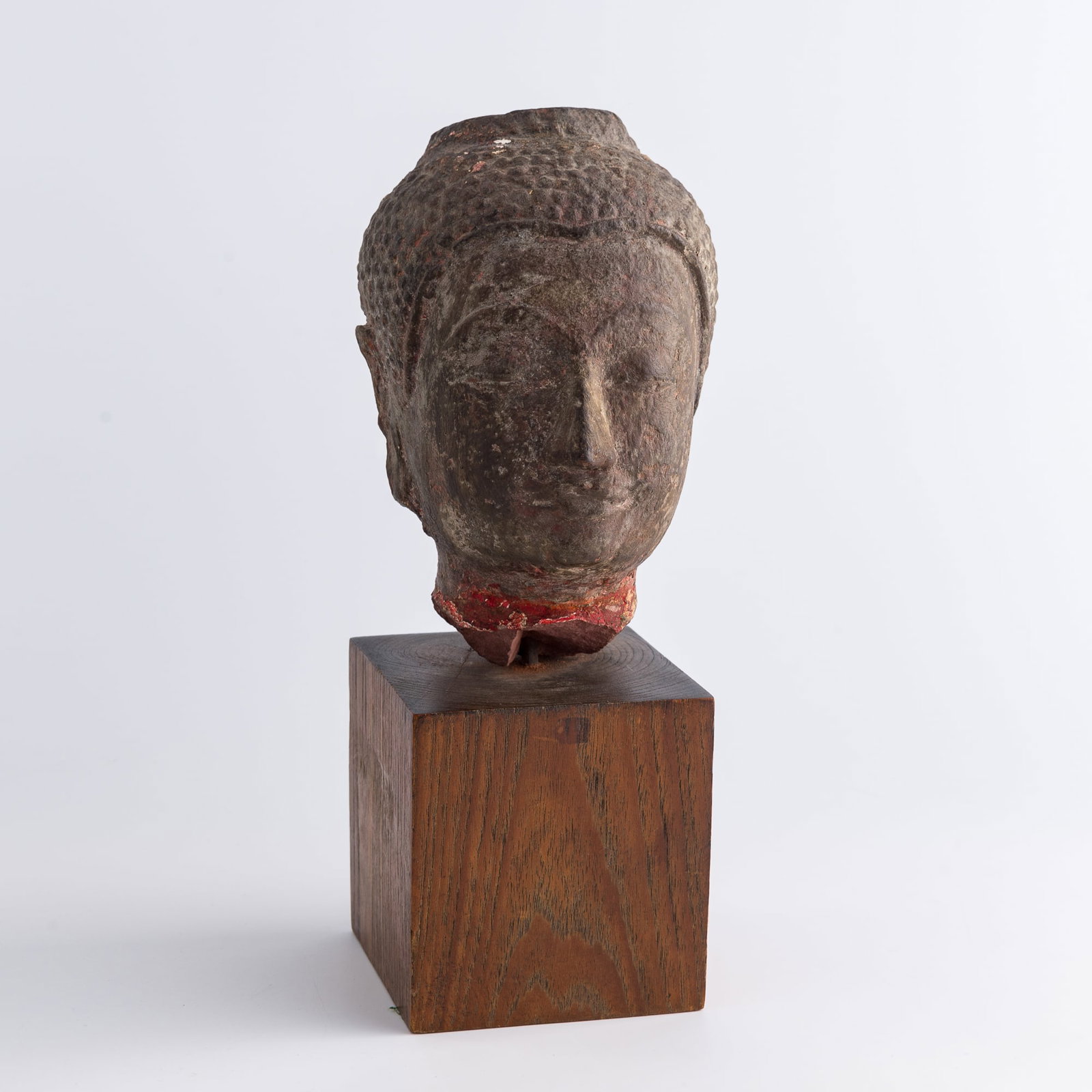 A Chinese carved stone Buddha head, Tang dynasty or earlier: A Chinese carved stone Buddha head Tang dynasty or earlier includes wooden stand H: 8, W: 4 1/2, D: 5 1/2 in. (H: 20.3, W: 11.4, D: 14 cm.) From an estate in San Diego, California.