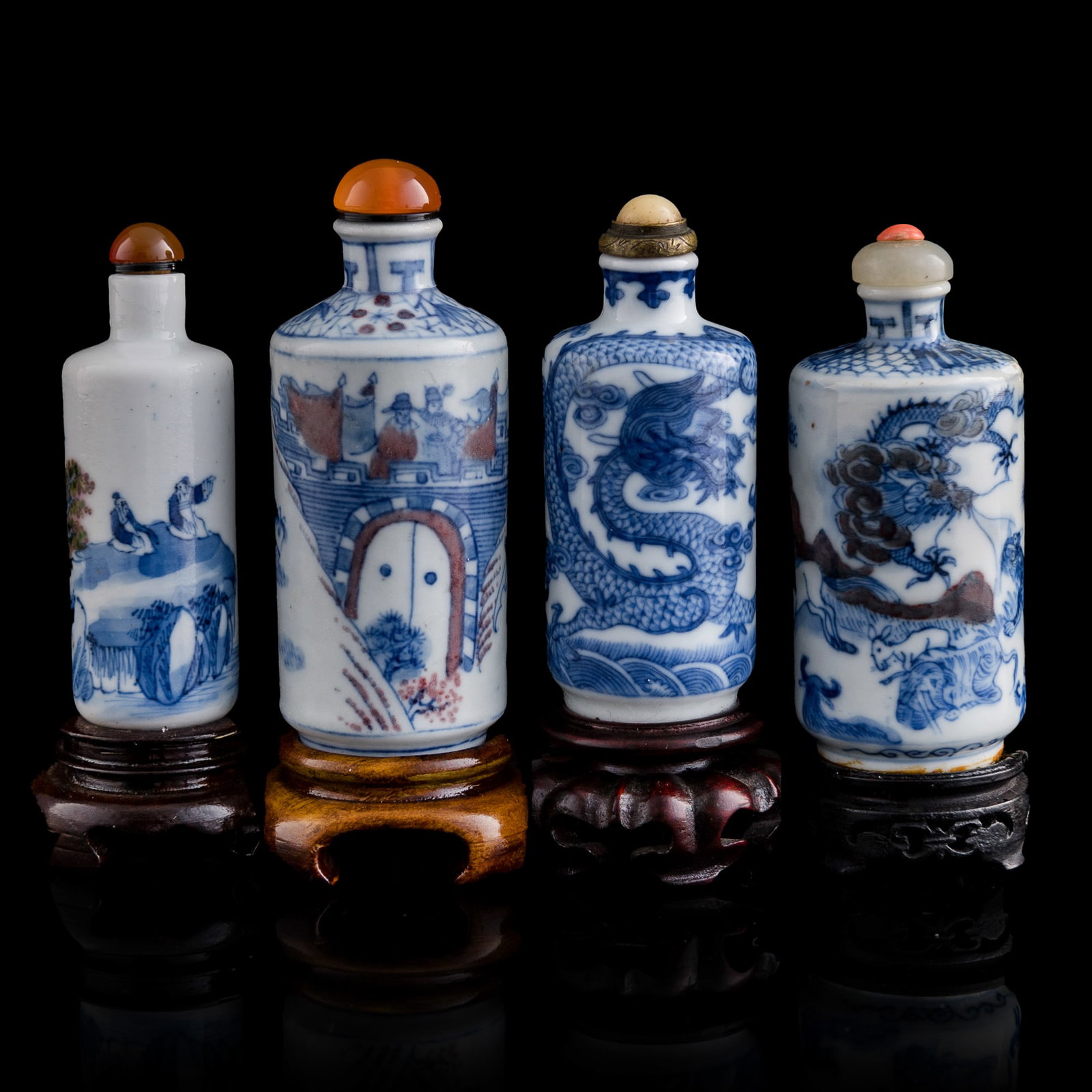 Four Chinese blue and white and underglaze-red snuff bottles, 19th century: Four Chinese blue and white and underglaze-red snuff bottles 19th century one with six-character marking to underside and one with four-character marking to underside; each with wooden stand (4) H: 4,