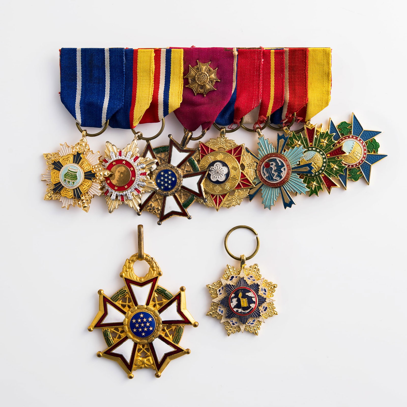 A group of nine Chinese- and American-style enameled medals, 20th century or later: A group of nine Chinese- and American-style enameled medals 20th century or later Seven mounted together and two loose. (9). H: 3, W: 2 1/4, D: 1/4 in. (H: 7.6, W: 5.7, D: 0.6 cm. (largest unmounted b