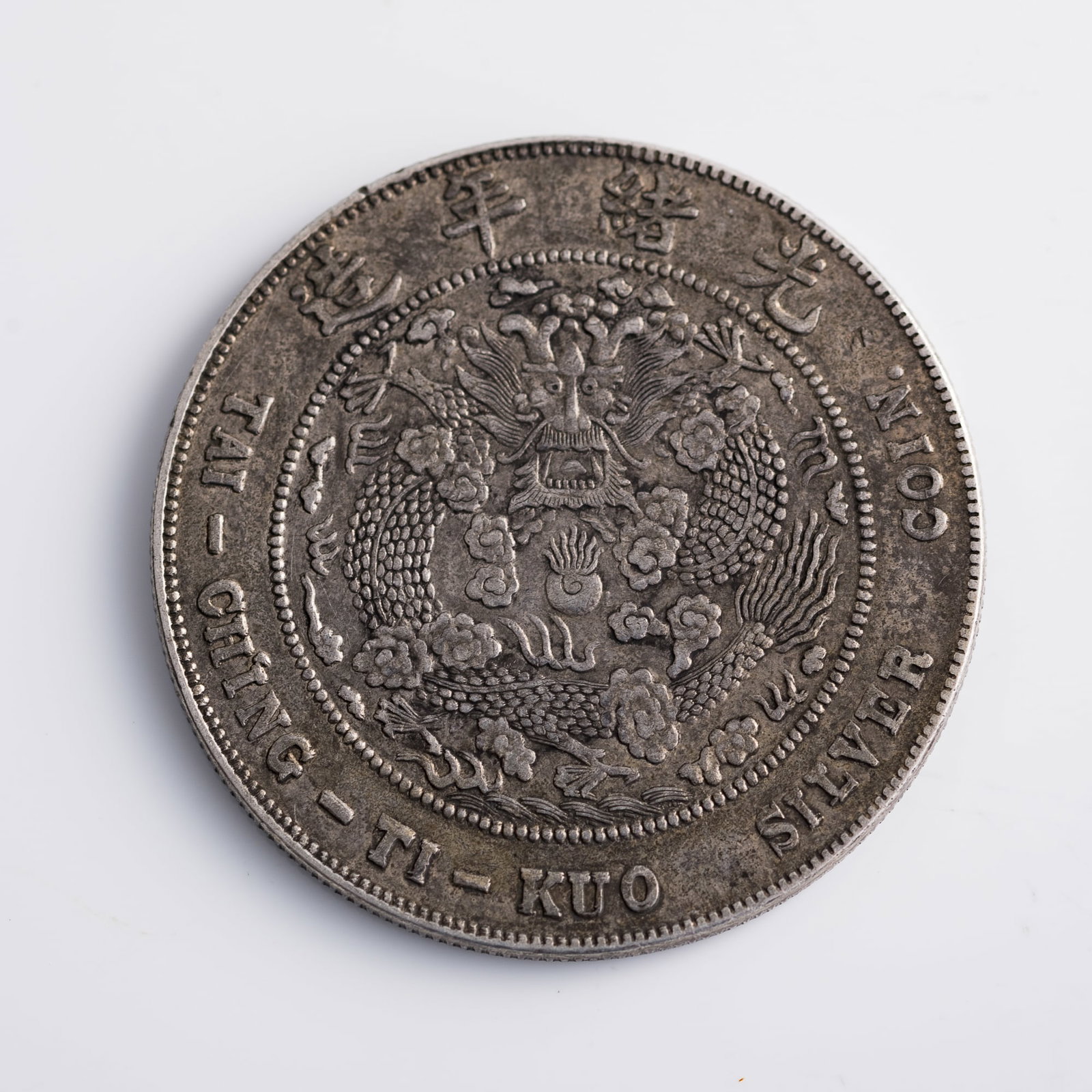 A Central Mint Guangxu Yuanbao silver coin, Kuping 7 Mace 2 Candareens, Qing dynasty: A Central Mint Guangxu Yuanbao silver coin, Kuping 7 Mace 2 Candareens Qing dynasty Dia: 39.5, D: 2.5 mm. Weight: 26.82 g From Mr. Hsu in Chicago, Illinois; a family inheritance.
