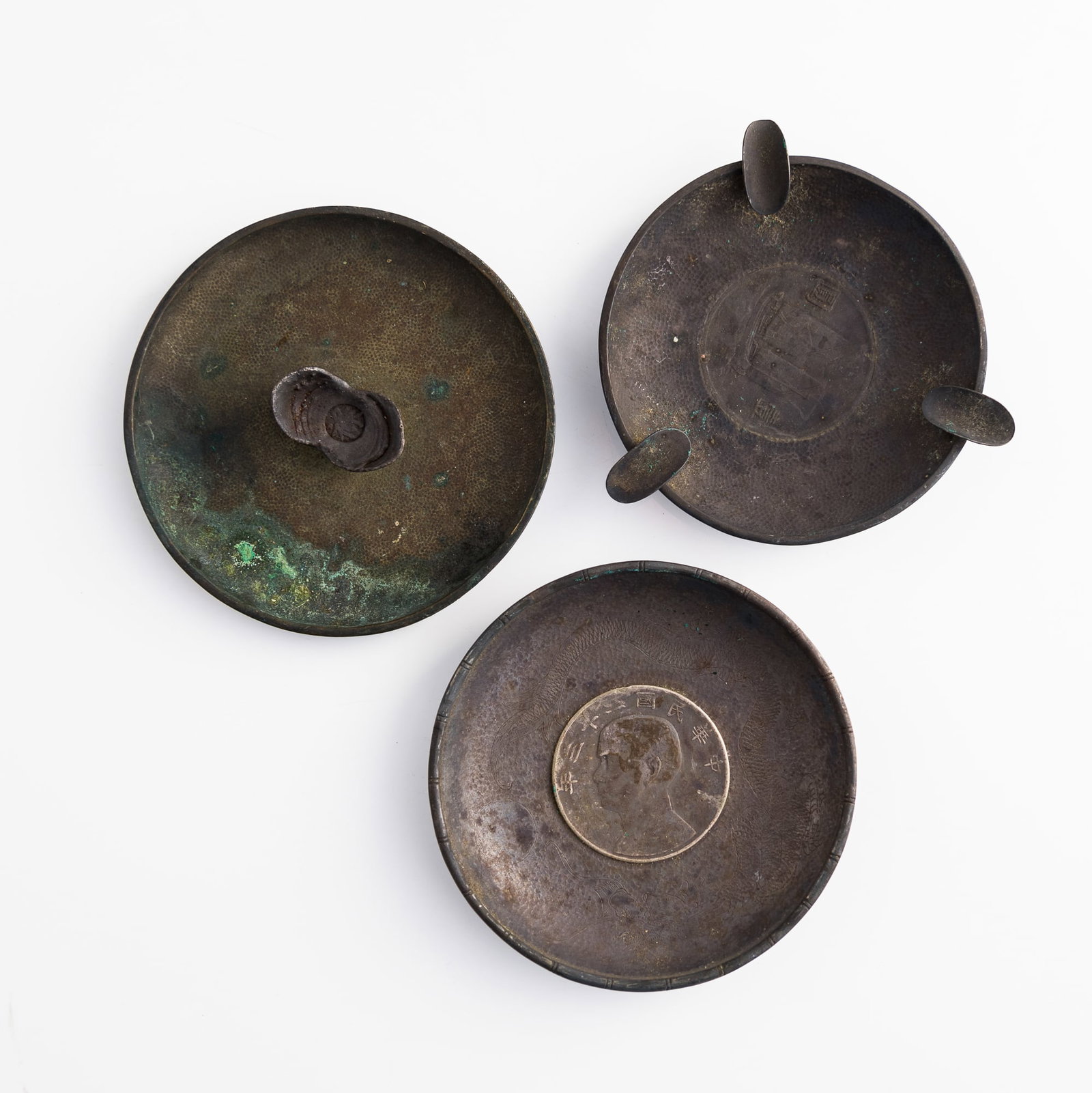Three Chinese silver ashtrays, two inset with coins and one with a sycee, Republic period: Three Chinese silver ashtrays, two inset with coins and one with a sycee Republic period Ashtray: H: 1/2, Dia: 3 5/8 in. (H: 1.3, Dia: 9.2 cm. (largest)) Coin dimension: 39.6 mm and 39.4 mm Weight