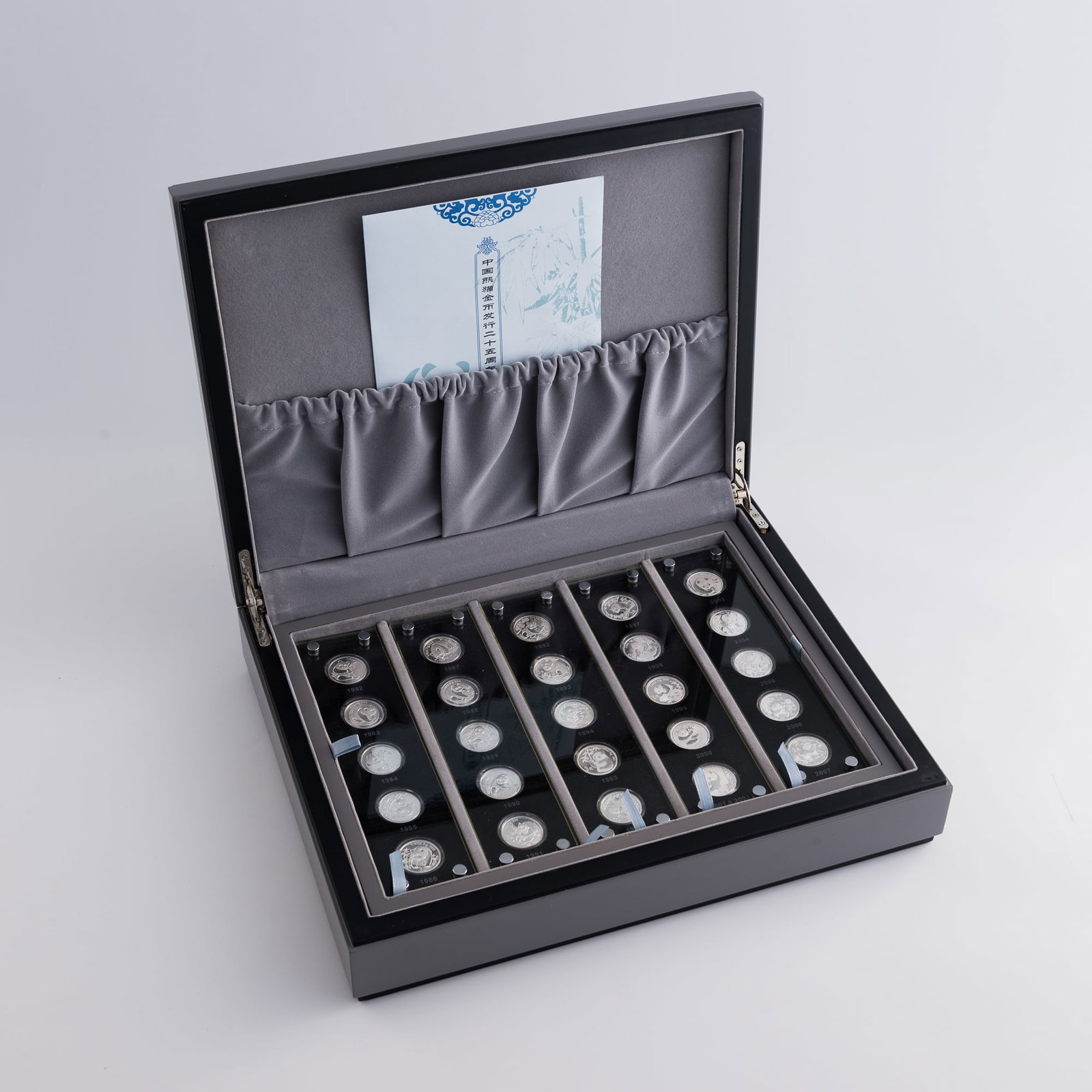 A collection of twenty-five Chinese silver panda coins, 1982-2007: A collection of twenty-five Chinese silver panda coins 1982-2007 Each coin with 'three yuan' value on front. Coins are housed in a custom case. Case comes with certificate of authenticity from The
