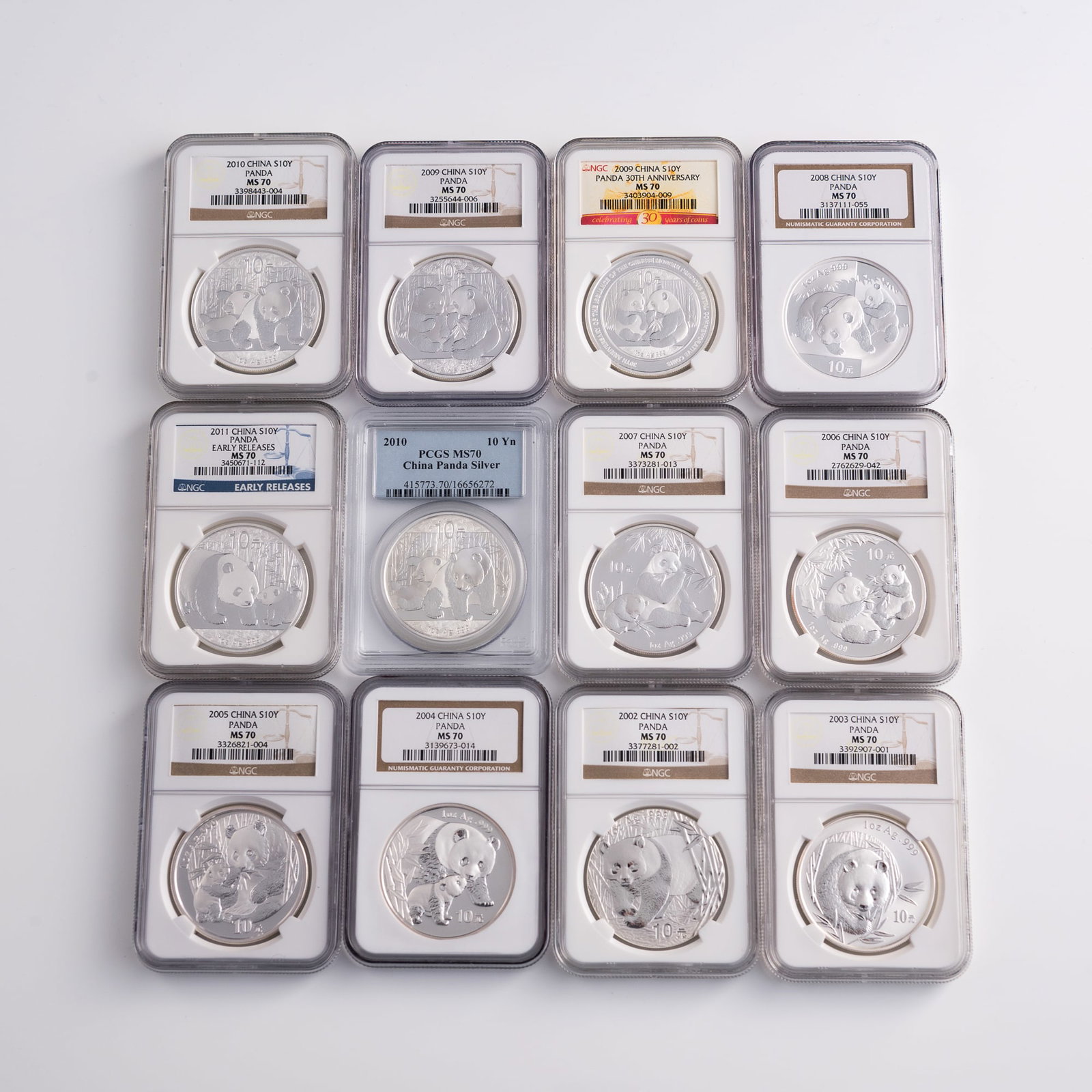 Twelve graded Chinese silver panda coins, 2002-2011: Twelve graded Chinese silver panda coins 2002-2011 Each coin graded by either Numismatic Guaranty Corporation or PCGS. One coin for each year, plus one additional coin for 2009 and 2010. 2011 coin is 