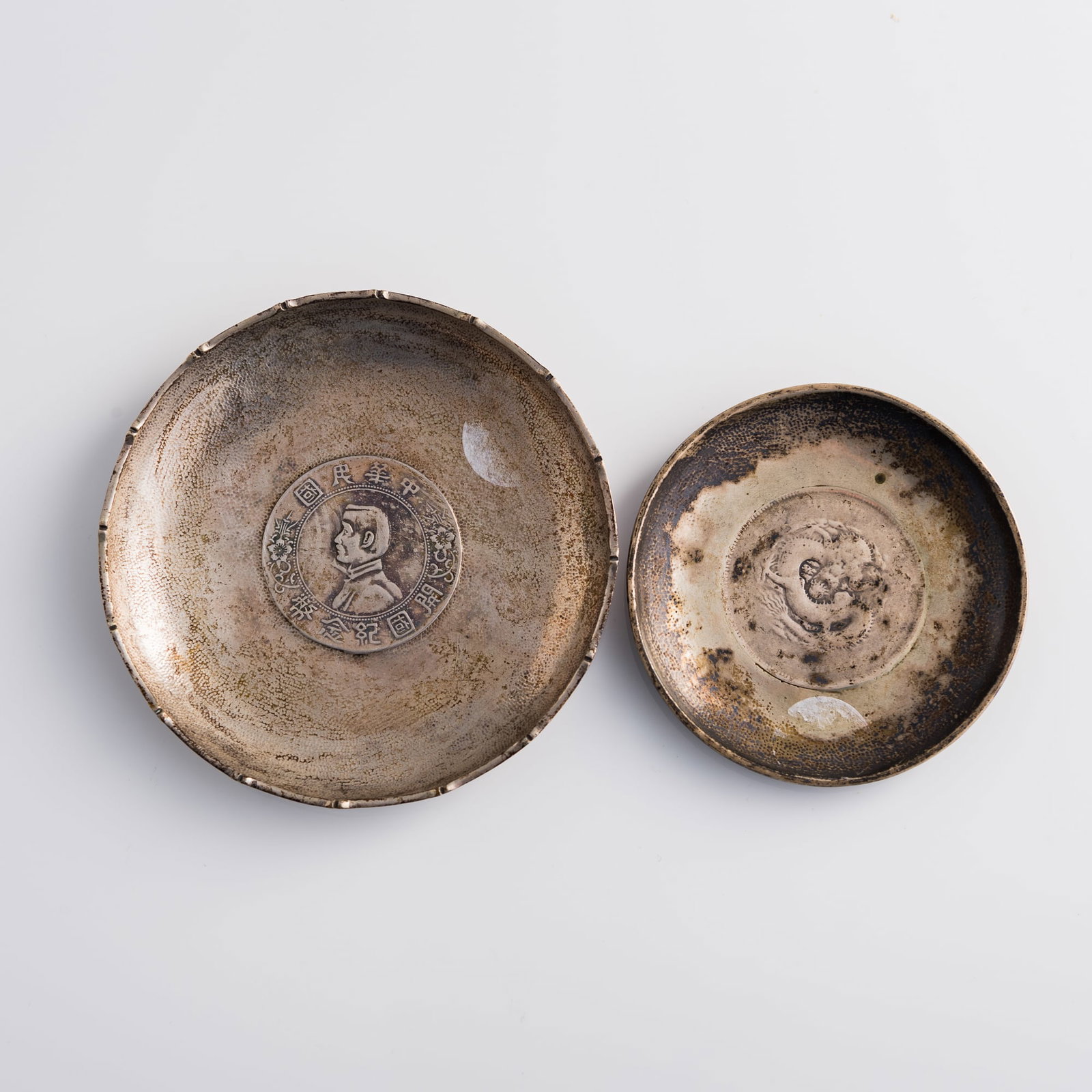 Two silver dishes inset with Chinese silver coins: Two silver dishes inset with Chinese silver coins Coin Diameter: 39.2 mm and 38.6 mm Dish: H: 1/2, Dia: 3 7/8 in. (H: 1.3, Dia: 9.8 cm. (largest)) Weight: 53.96 g and 59.83 g Private collector, Seattl