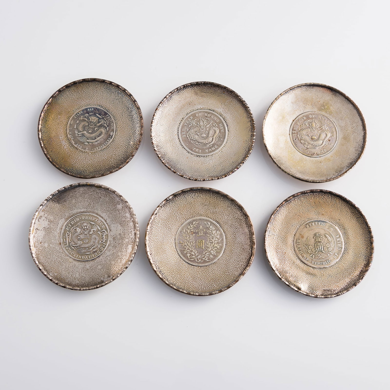Six silver dishes inset with Chinese silver coins: Six silver dishes inset with Chinese silver coins Coin Diameter range: 38.3-39.2 mm Dish: H: 1/2, Dia: 3 1/2 in. (H: 1.3, Dia: 8.9 cm. (largest)) Weight range: 48.36-62.84 g Private collector, Minneso