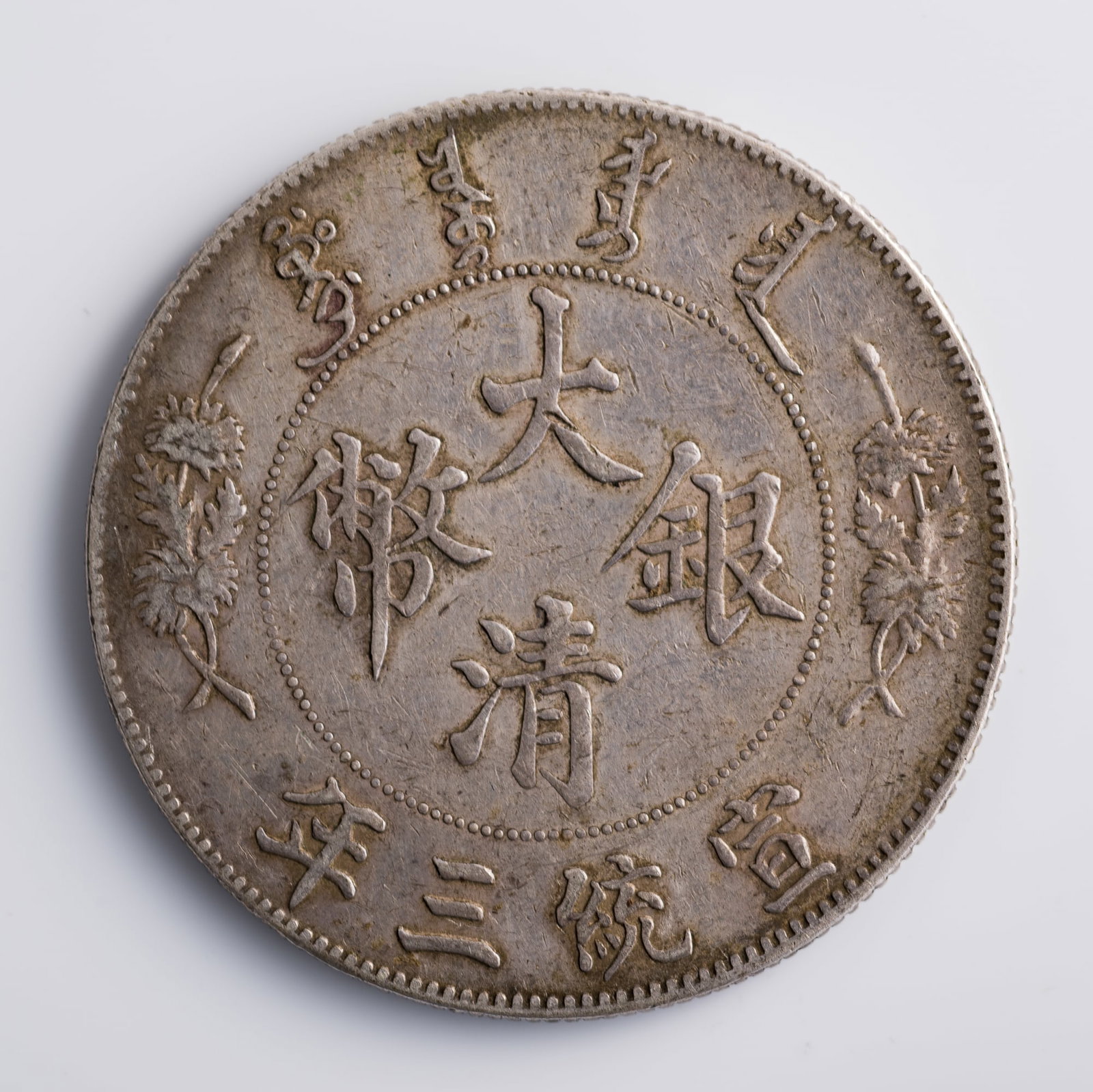 A Xuantong Year 3 Great Qing one-dollar silver coin, 1911: A Xuantong Year 3 Great Qing one-dollar silver coin 1911 Dia: 39, D: 2.3 mm. Weight: 26.77 g From Mr. Shang of Wake Forrest, North Carolina; inherited from his father.
