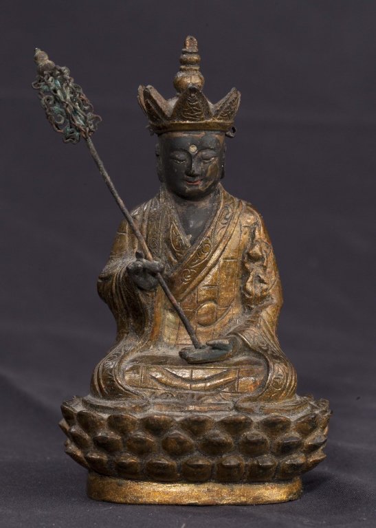 A gilt bronze seated Buddha Ming dynasty: A gilt bronze seated Buddha Ming dynasty seated on top of a lotus pedestal with a pointed crown and holding a Buddhist talisman approximately 4 1/4in high.