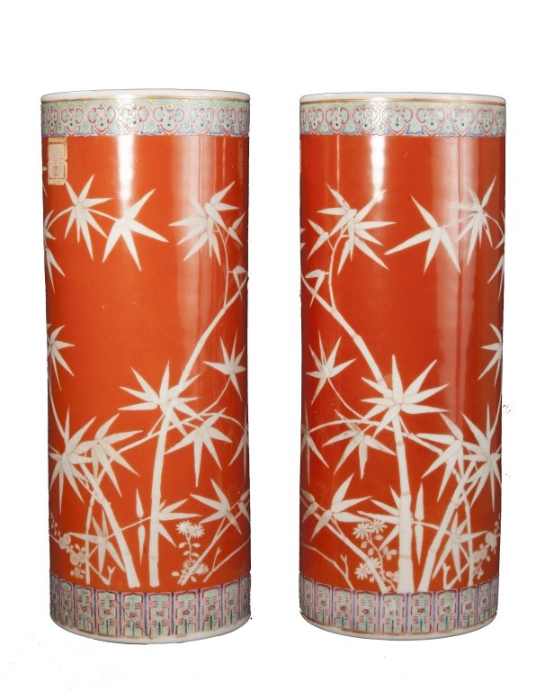 A pair of hat stands late Qing/Republic period: A pair of coral-ground reverse-decorated hat stands depicting bamboo late Qing/Republic period each of cylindrical form and reverse-decorated depicting bamboo six character Qianlong mark approximately