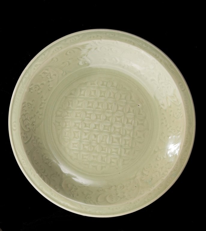 A Longquan celadon plate early Ming dynasty: A large Longquan celadon plate early Ming dynasty thickly glazed with a raised border and incised with a square geometric pattern in the center and a flower pattern on the side approximately 17in in d