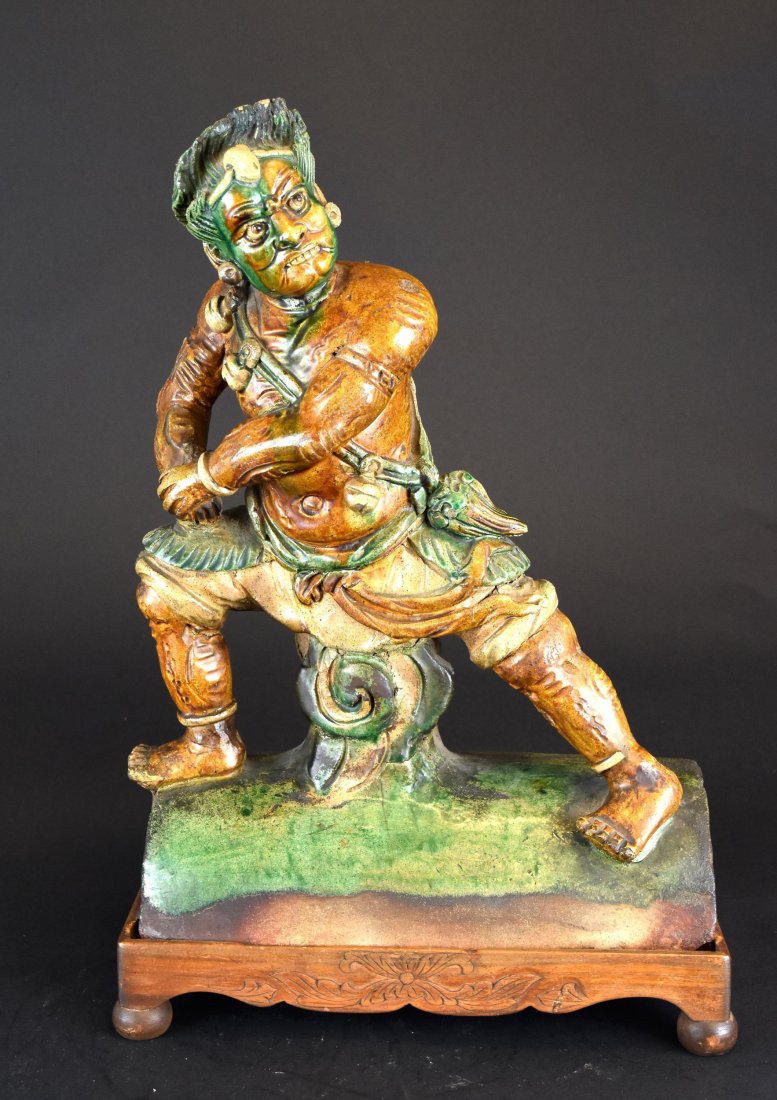 A Sancai Warrior Roof Tile, Ming Dynasty: A Chinese Sancai Warrior Roof Title, Ming Dynasty (1368-1644) This sancai roof tile is in the shape of a warrior. The warrior has a face mask and head gear and is looking toward the left with a fierce