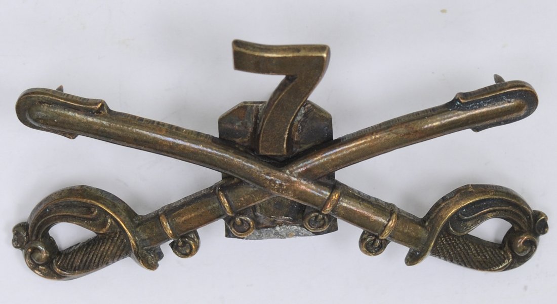 US-Indian Wars 7th Cavalry Cap/Kepi Badge: US Indian Wars Army 7th Cavalry Enlisted Mans Cap/Kepi Badge Custer Era. Measures 2 7/16" wide by 1 5/16" tall. Has a screw mount post and nut on the reverse side. Three piece brass construction. Cond
