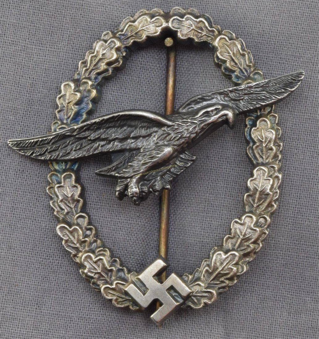 German World War II Luftwaffe Glider Pilot Badge: German World War II Luftwaffe Glider Pilot Badge. The reverse side is maker marked 'C E Junker Berlin SW'. Has a thin vertical 'T' bar style pin back. Two piece two domed rivet nickel construction. No