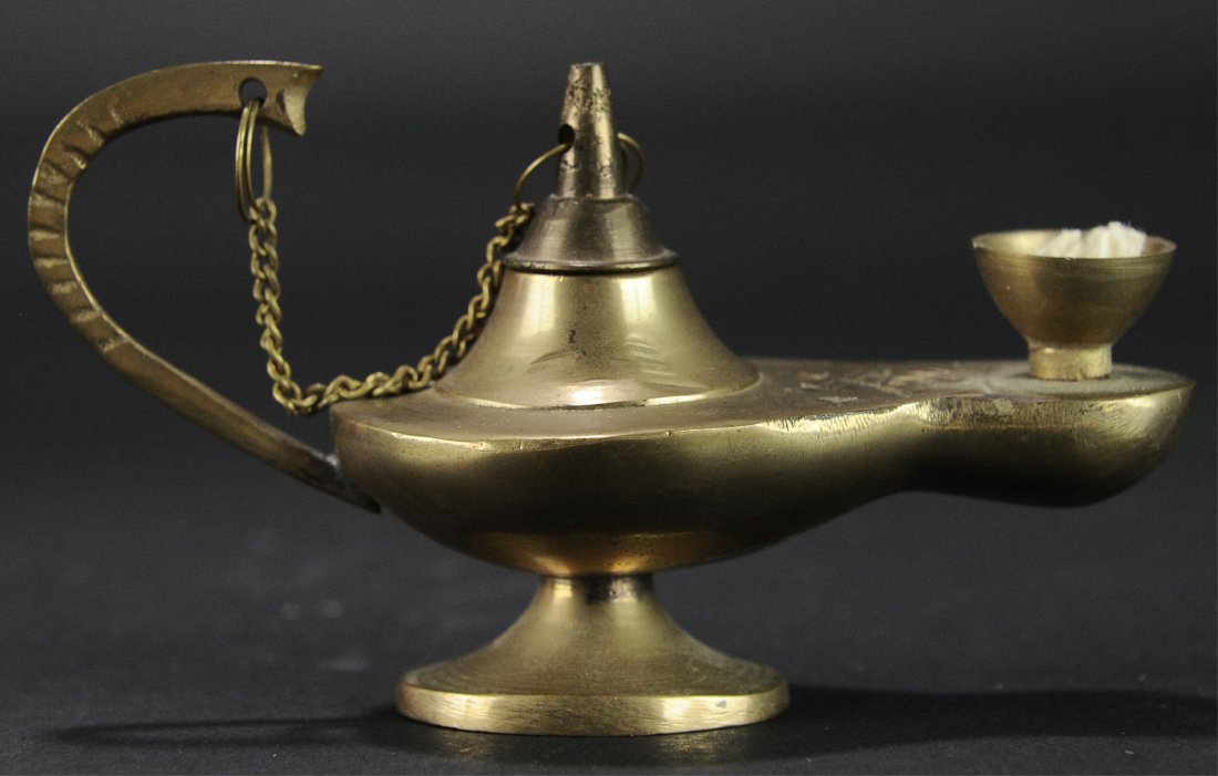 Arabian Oil Lamp: Arabian Oil Lamp. Approximately 4 1/4 inches long X 2 1/4 inches high, this brass oil lamp has a double sword design, and a lid that is attached with a chain. Condition: It is in good condition.
