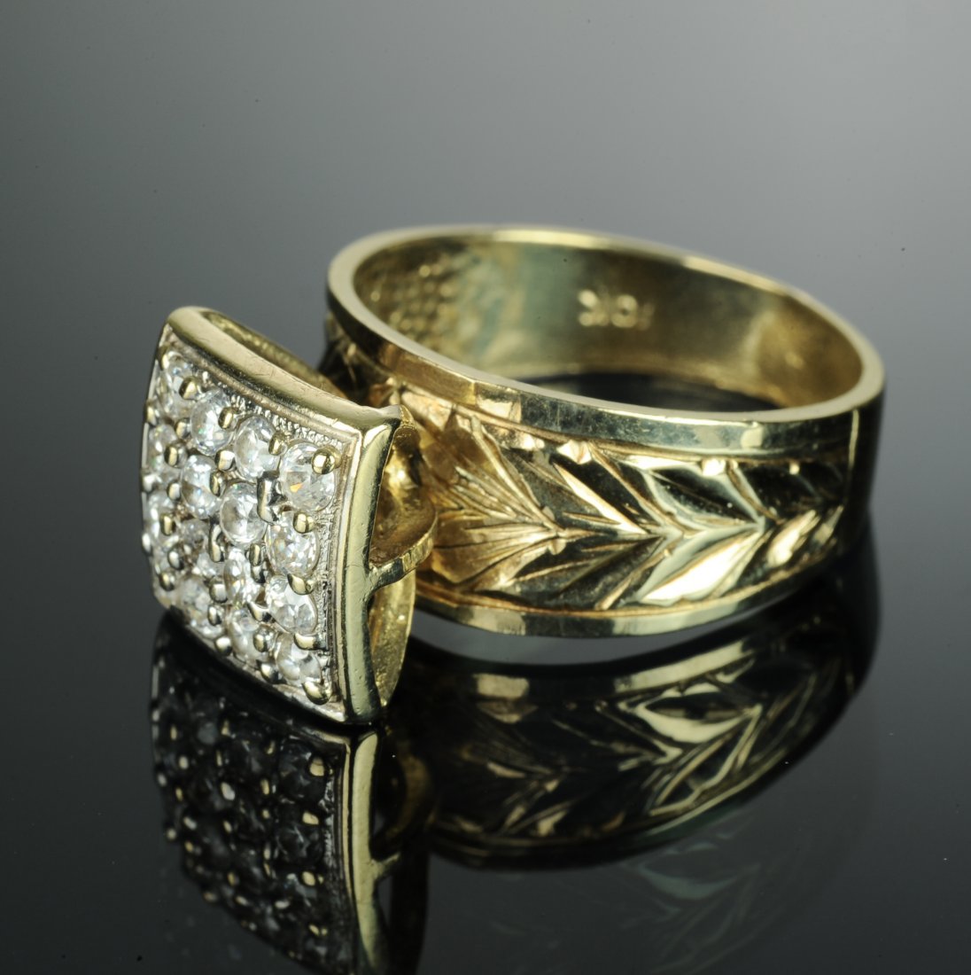 10K Yellow Gold Fashion Ring: 10K Yellow Gold Fashion Ring. Set in 10K yellow gold are 16 round cut, 2.5mm*, gemstones in a 4 X 4 grid pattern. The gold band has a leaf design. One side of the shank is stamped with 10K and the oth