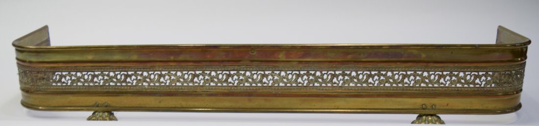 Brass Fireplace Fender: Brass Fireplace Fender. This ornate fender has 4 clawed feet stands and is approximately 50 inches by 14 inches by 7 1/4 inches high. Condition: It shows signs of weathering and age but is in good sha