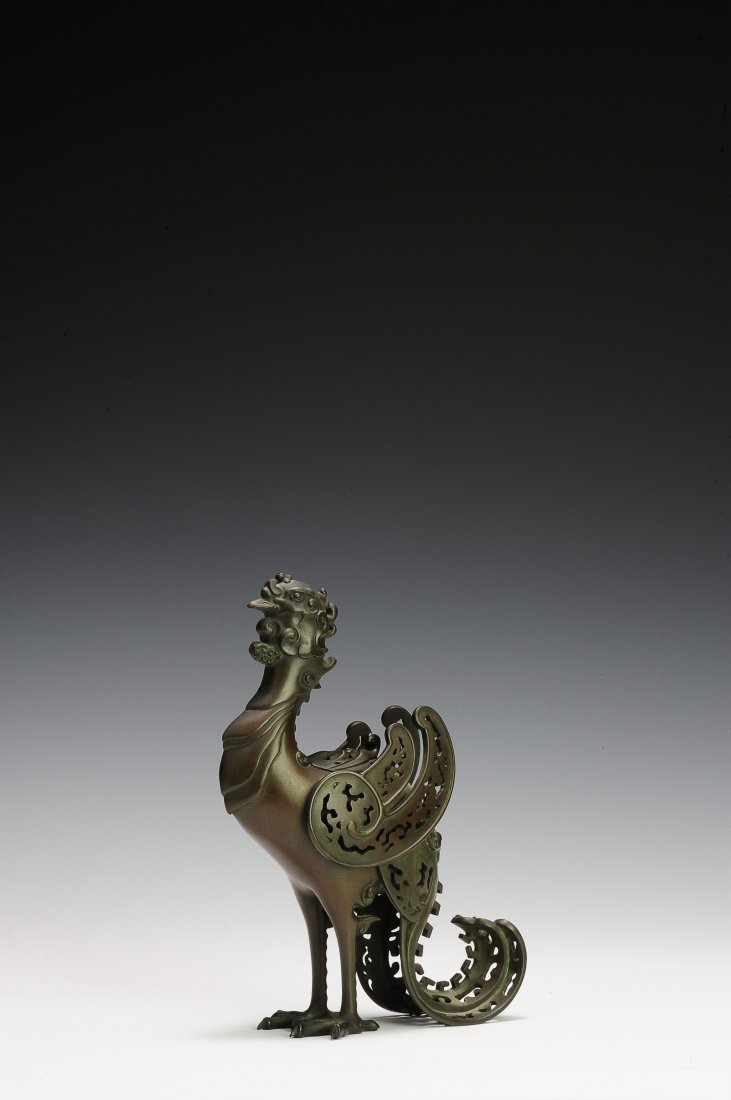 Japanese Phoenix Incense Burner, 19th Century: Japanese, bronze incense burner in the form of a phoenix with a detachable lid between the wings on the back, from the 19th Century. The wings, lid, and tail are perforated with ornate designs. There 
