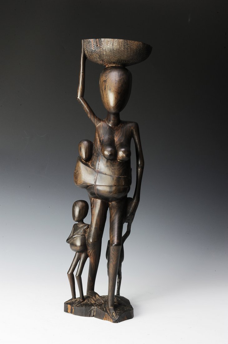 Vintage Ebony Makonde Sculpture: This ebony sculpture group is of a mother performing traditional tasks and three children. This carving displays the graceful, stylized forms of Makonde sculpture and appears to be carved out of a sin