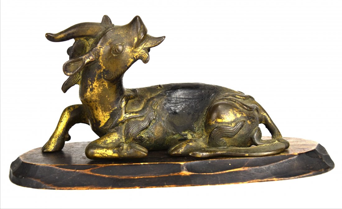 Gilded Bronze Single Horned Qilin, Ming Dynasty: Chinese gilded bronze single horned qilin from the Ming Dynasty (1368-1644). The qilin is lying down. It features a flaming mane and tail, and flames around the haunches and on the legs. The figure si