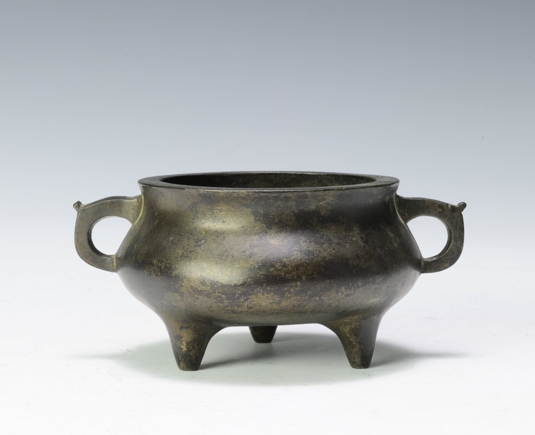 Small Bronze Tripod, 19th - 20th Century: Small bronze tripod incense burner with Xuande mark from the 19th - 20th century. It is short and round with two round handles. It has a Xuande seal mark on the bottom. Dimensions are 5 3/8 inches wid