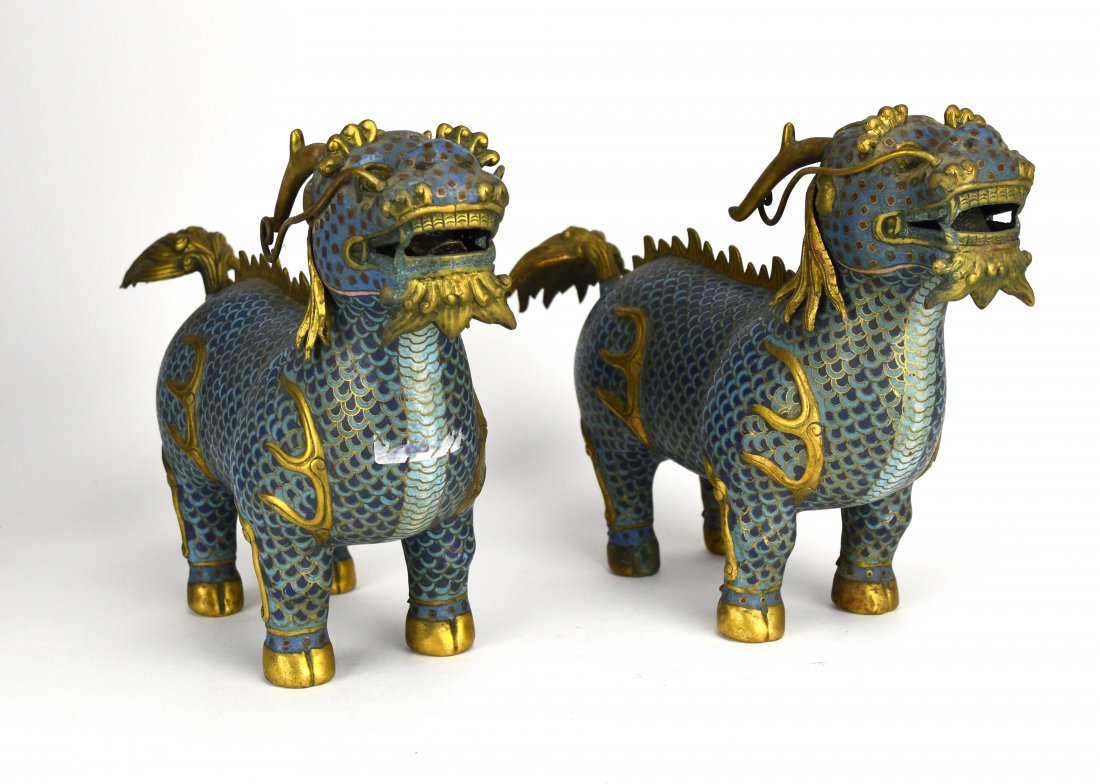 Two Cloisonné Qilin, Early 20th Century: Pair of Chinese cloisonné qilin from the early 20th century. They are enameled in cloud patterns on their bodies, have golden flaming manes and tails, and golden flames along their front and rear hau