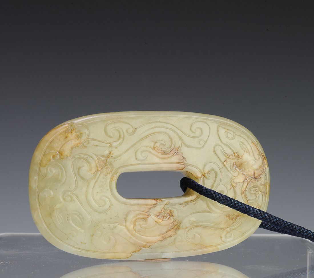 Celadon Jade Oval Shaped Bi, Ming Dynasty: Chinese pale green jade oval form Bi from the Ming Dynasty (1368-1644). On one side, two chilong are chasing each other, and are carved in bas relief. The other side is adorned with a series of circul